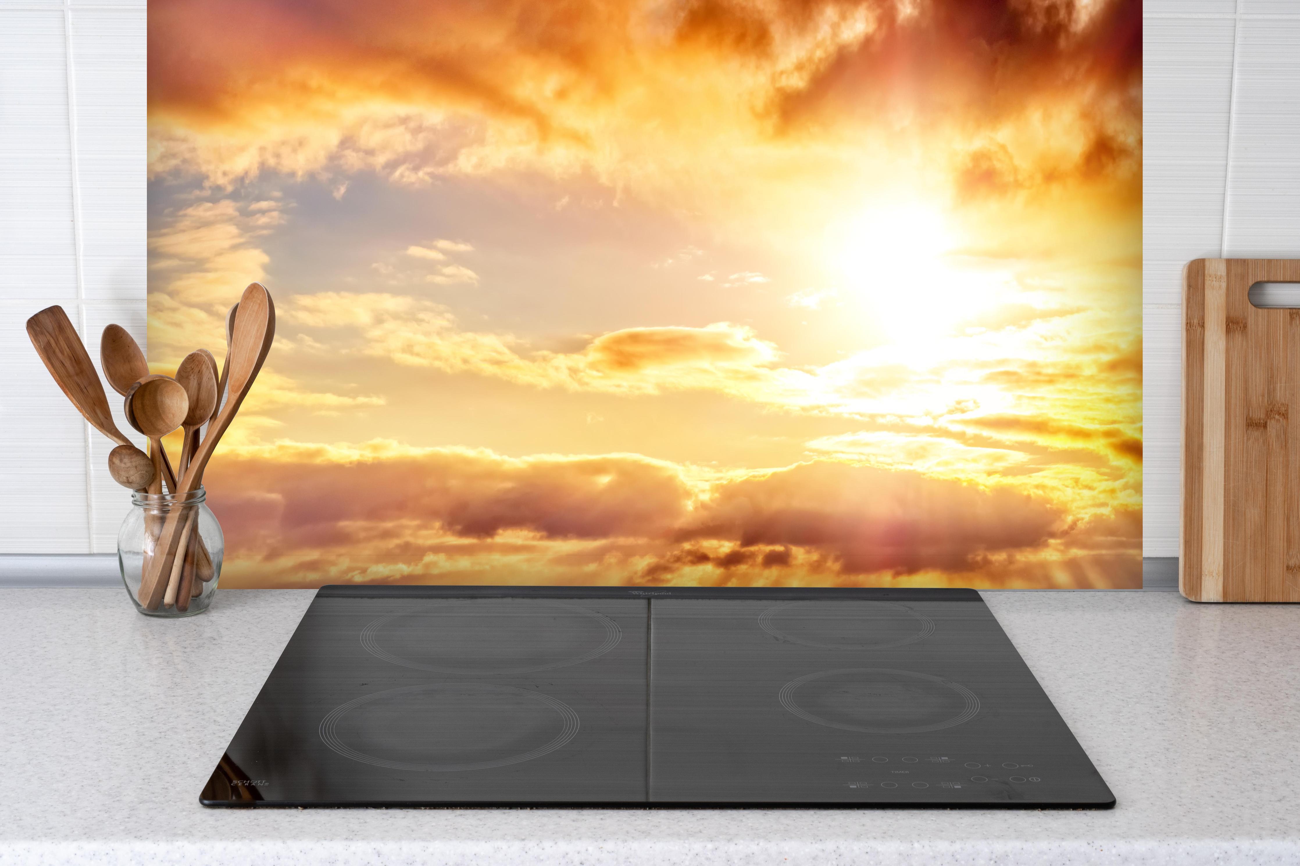 Spritzschutz - Blick zum schönen Sonnenuntergang hinter einem Cerankochfeld zwischen Holz-Kochutensilien
