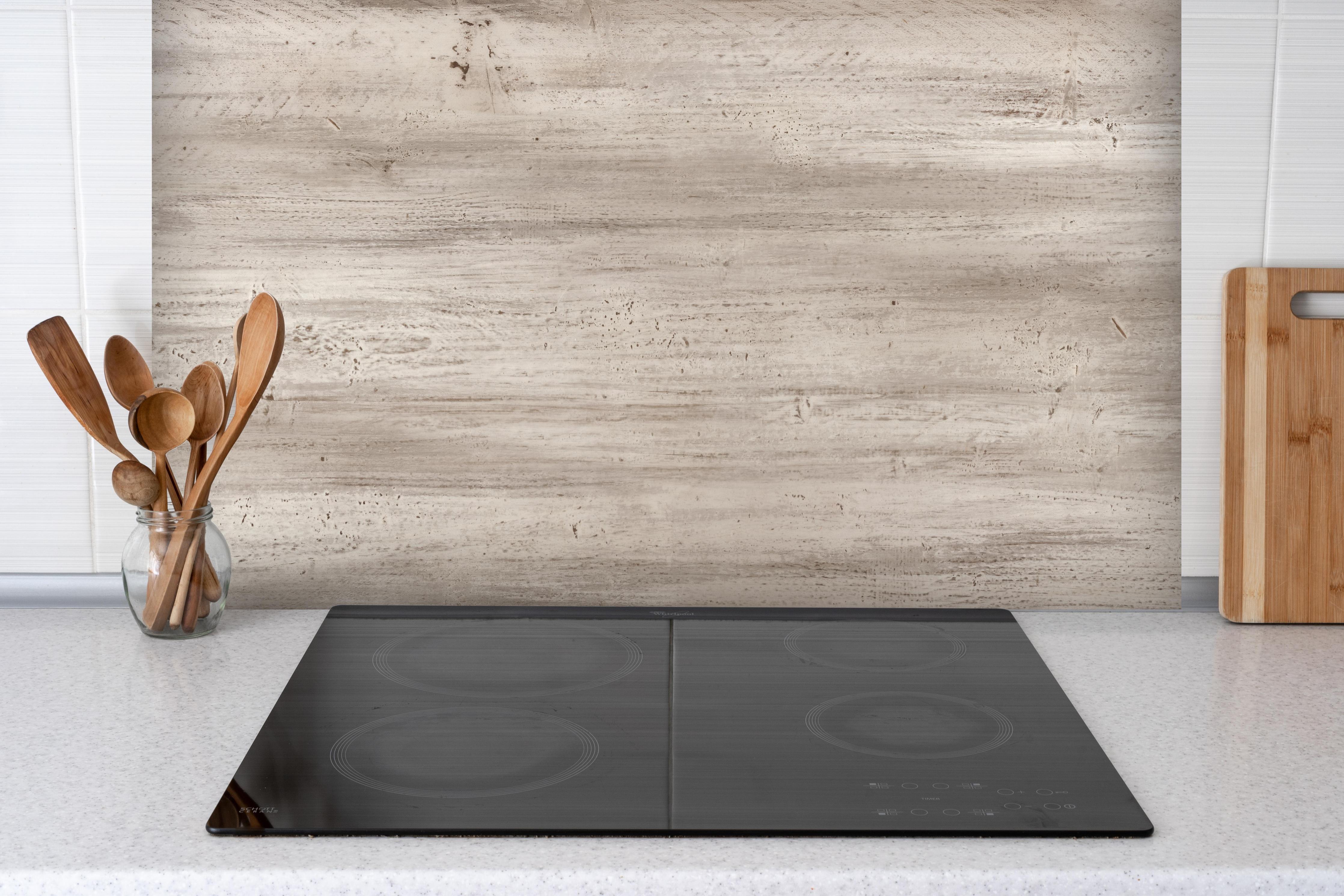 Spritzschutz - Bräunliche alte Holztextur hinter einem Cerankochfeld zwischen Holz-Kochutensilien