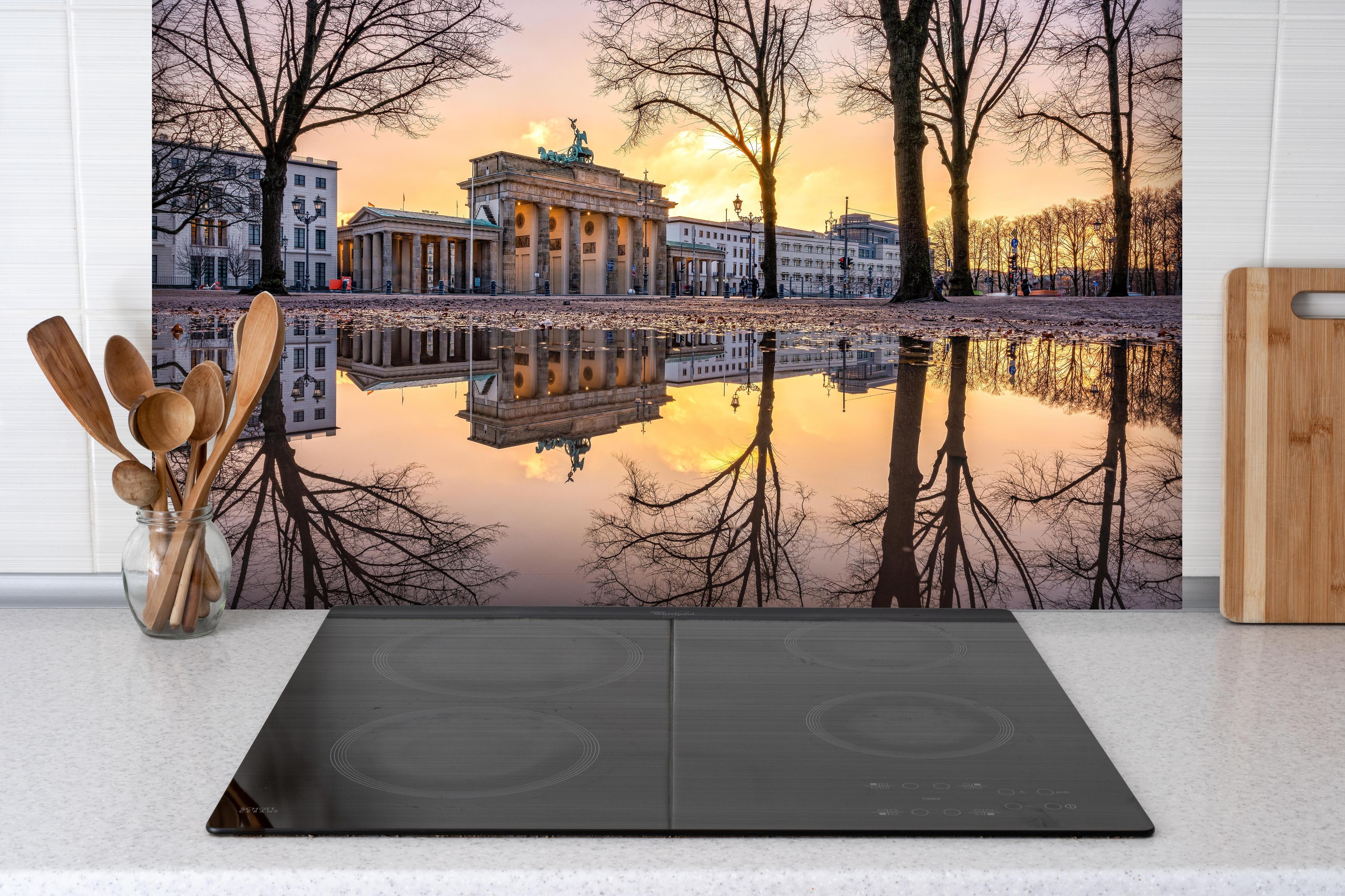 Spritzschutz - Brandenburger Tor im Winter hinter einem Cerankochfeld zwischen Holz-Kochutensilien