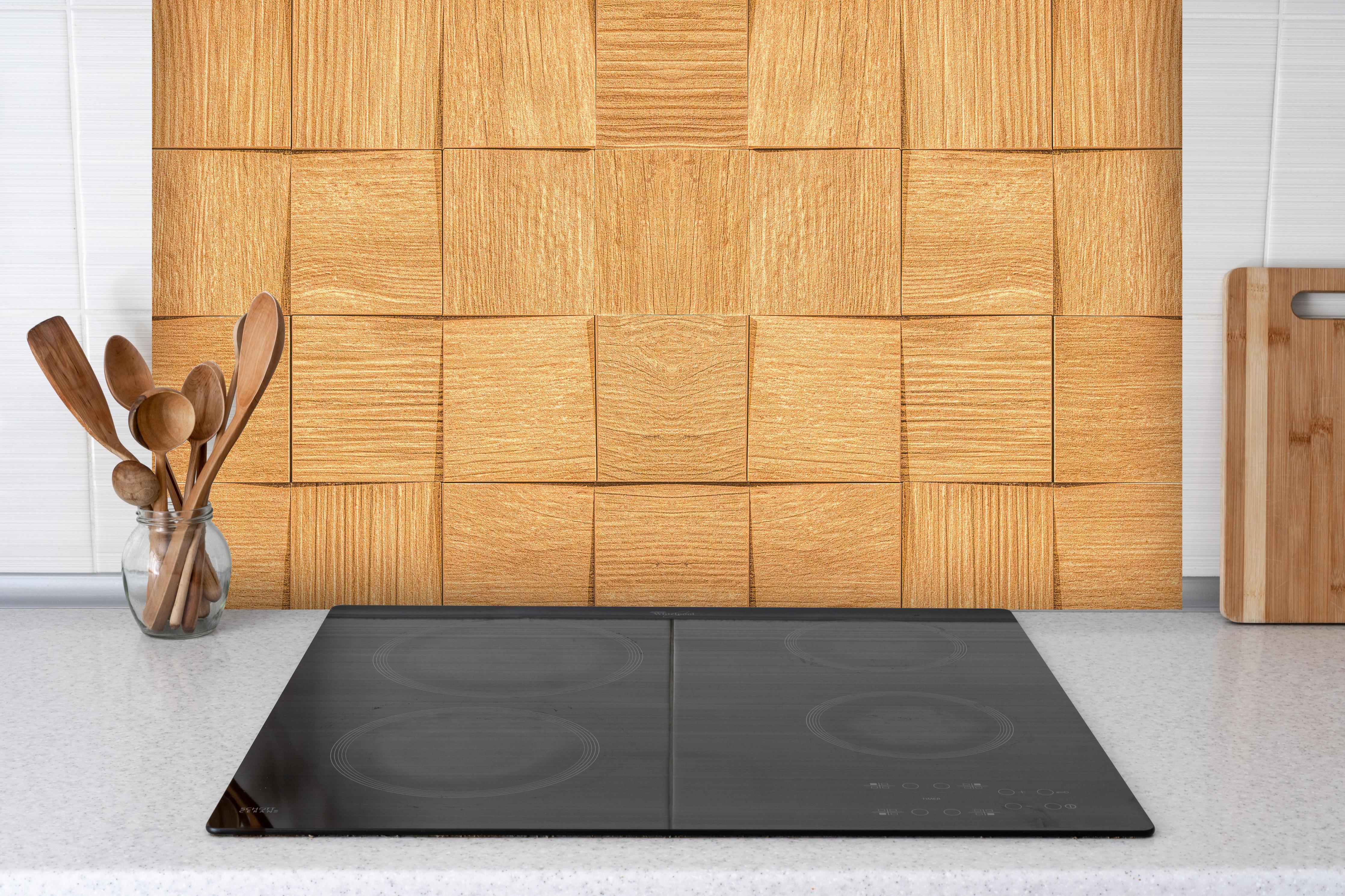 Spritzschutz - Braune Holzwürfeltextur hinter einem Cerankochfeld zwischen Holz-Kochutensilien