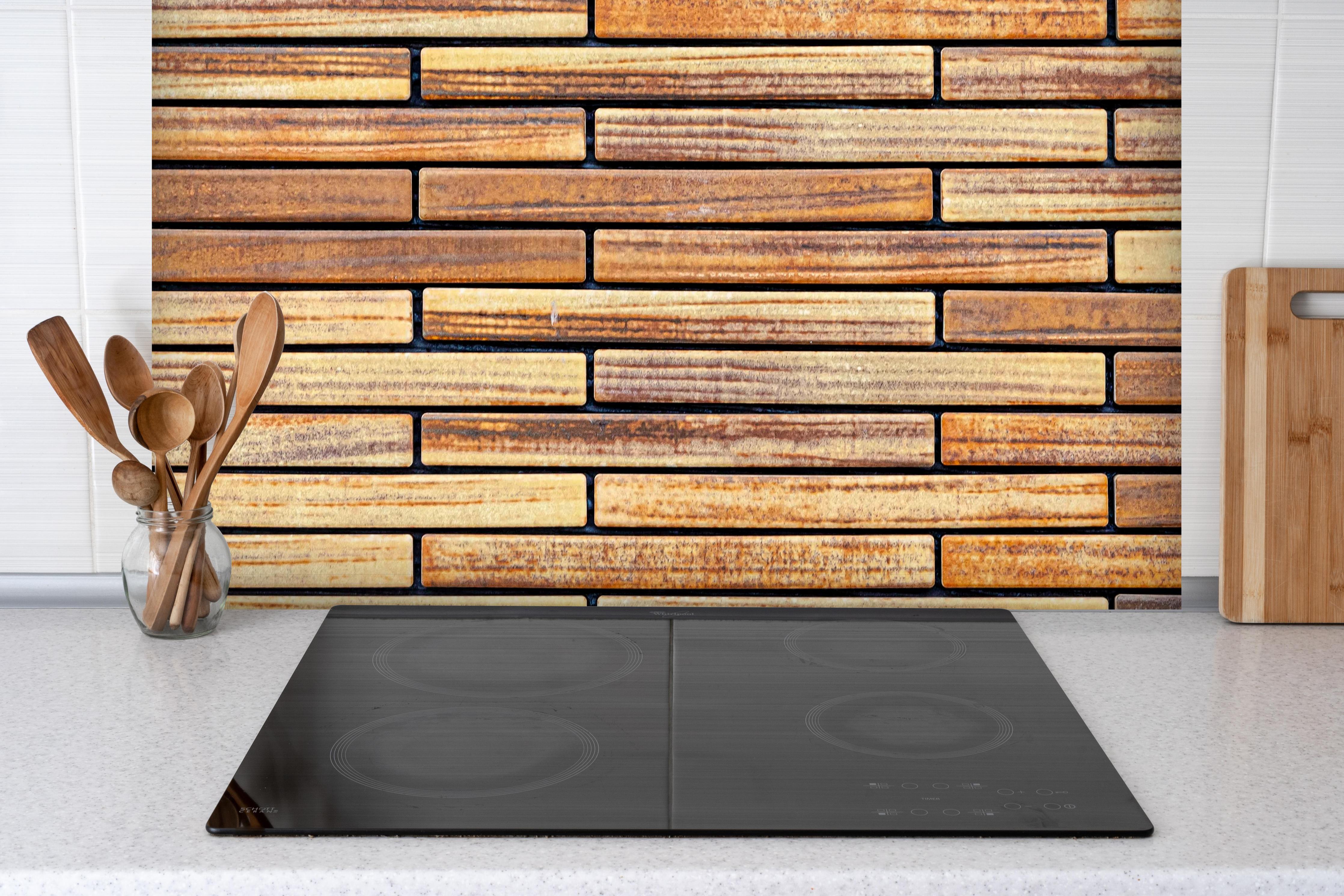 Spritzschutz - Brauner Sandstein Ziegelwand Muster hinter einem Cerankochfeld zwischen Holz-Kochutensilien