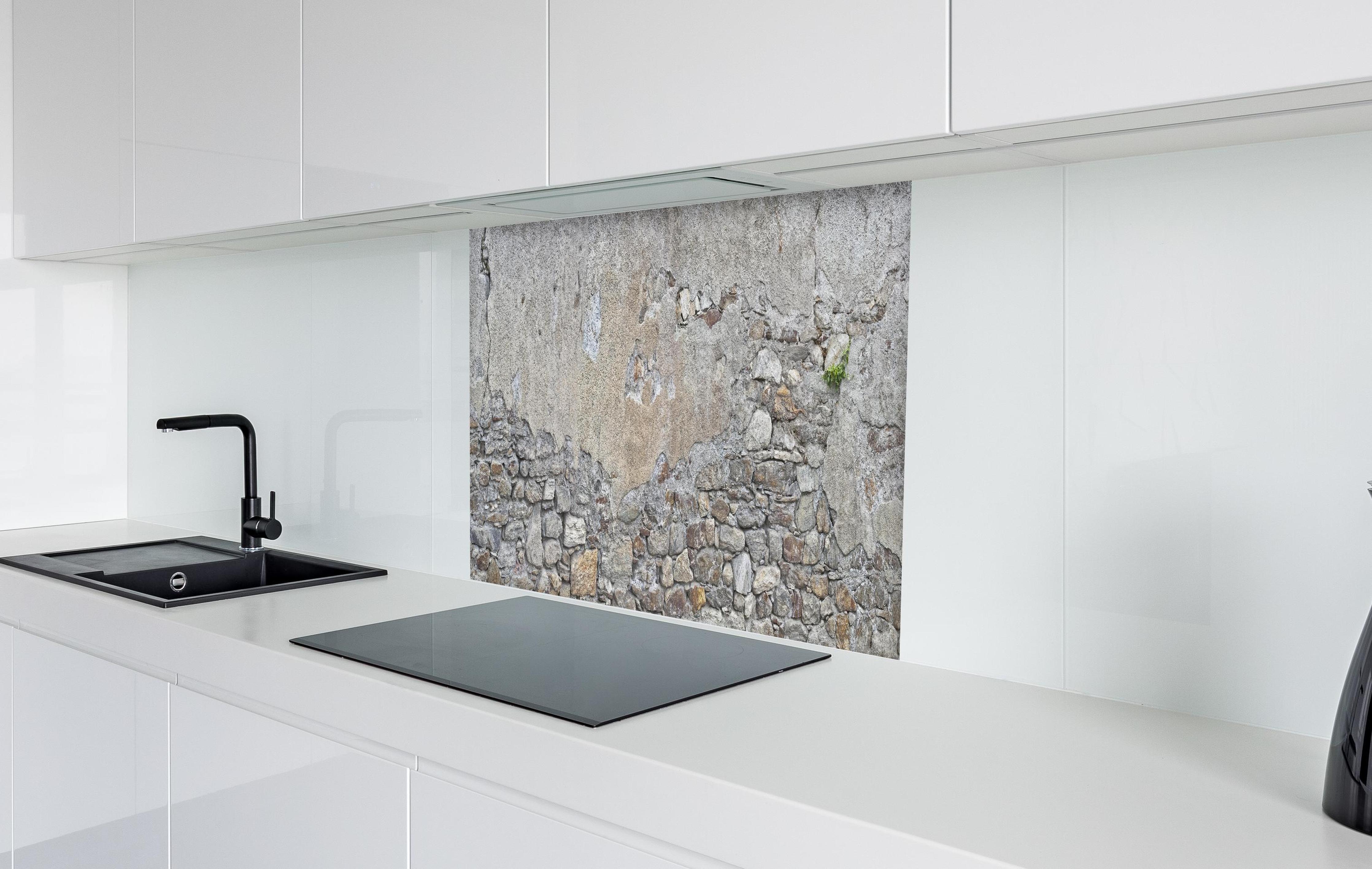 Spritzschutz - Bröckelnde Hausmauer in Südtirol in weißer Hochglanz-Küche hinter einem Cerankochfeld