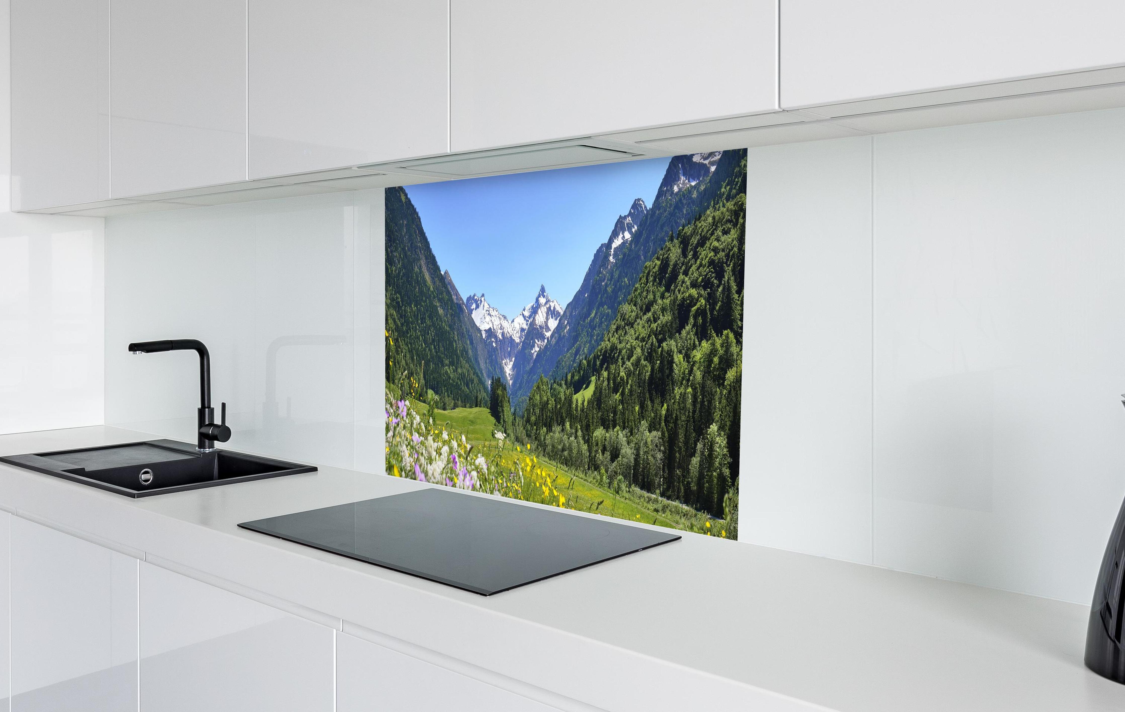 Spritzschutz - Bunte Wiese in den Alpen in weißer Hochglanz-Küche hinter einem Cerankochfeld