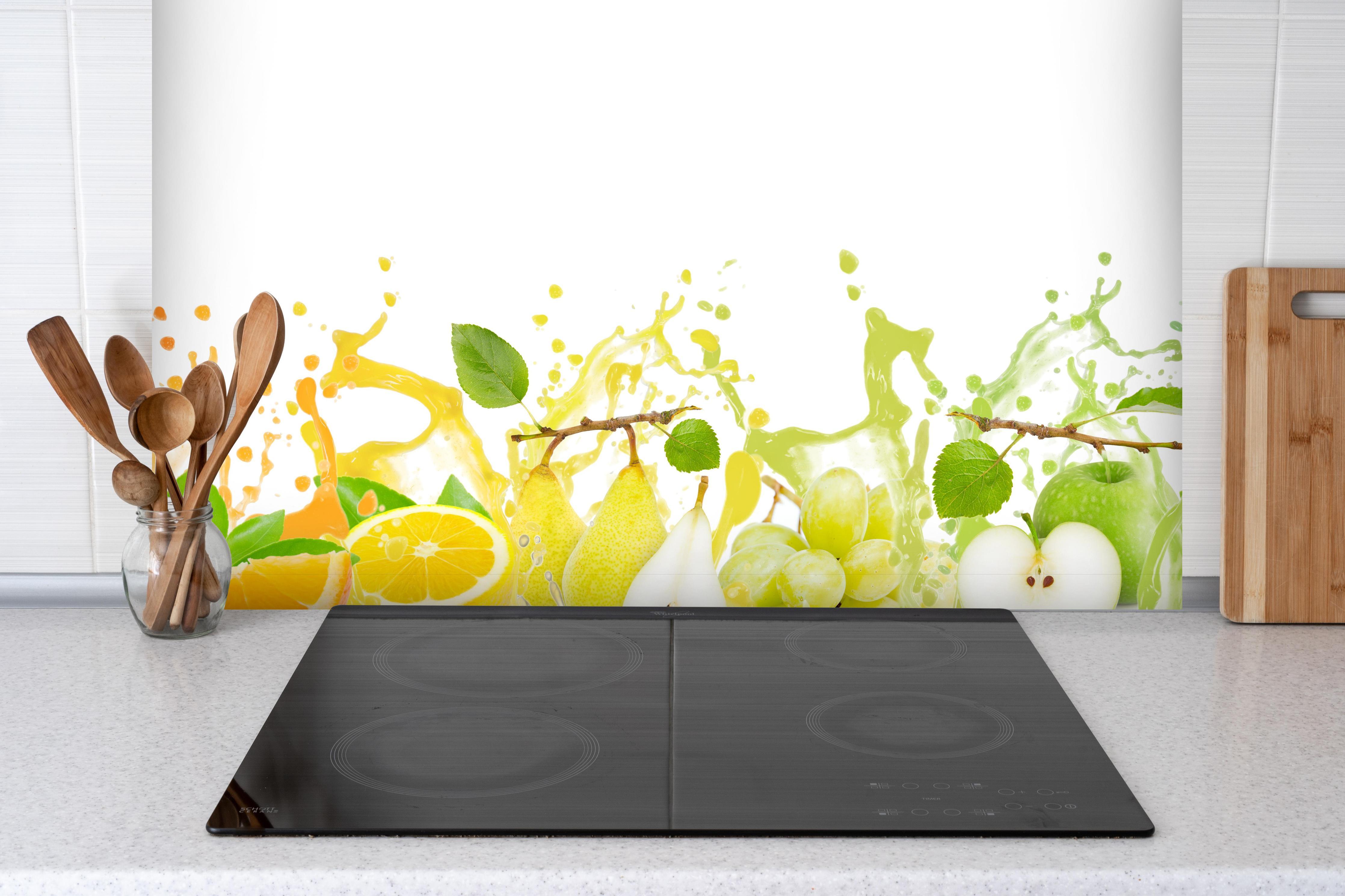 Spritzschutz - Bunte spritzige Früchte hinter einem Cerankochfeld zwischen Holz-Kochutensilien