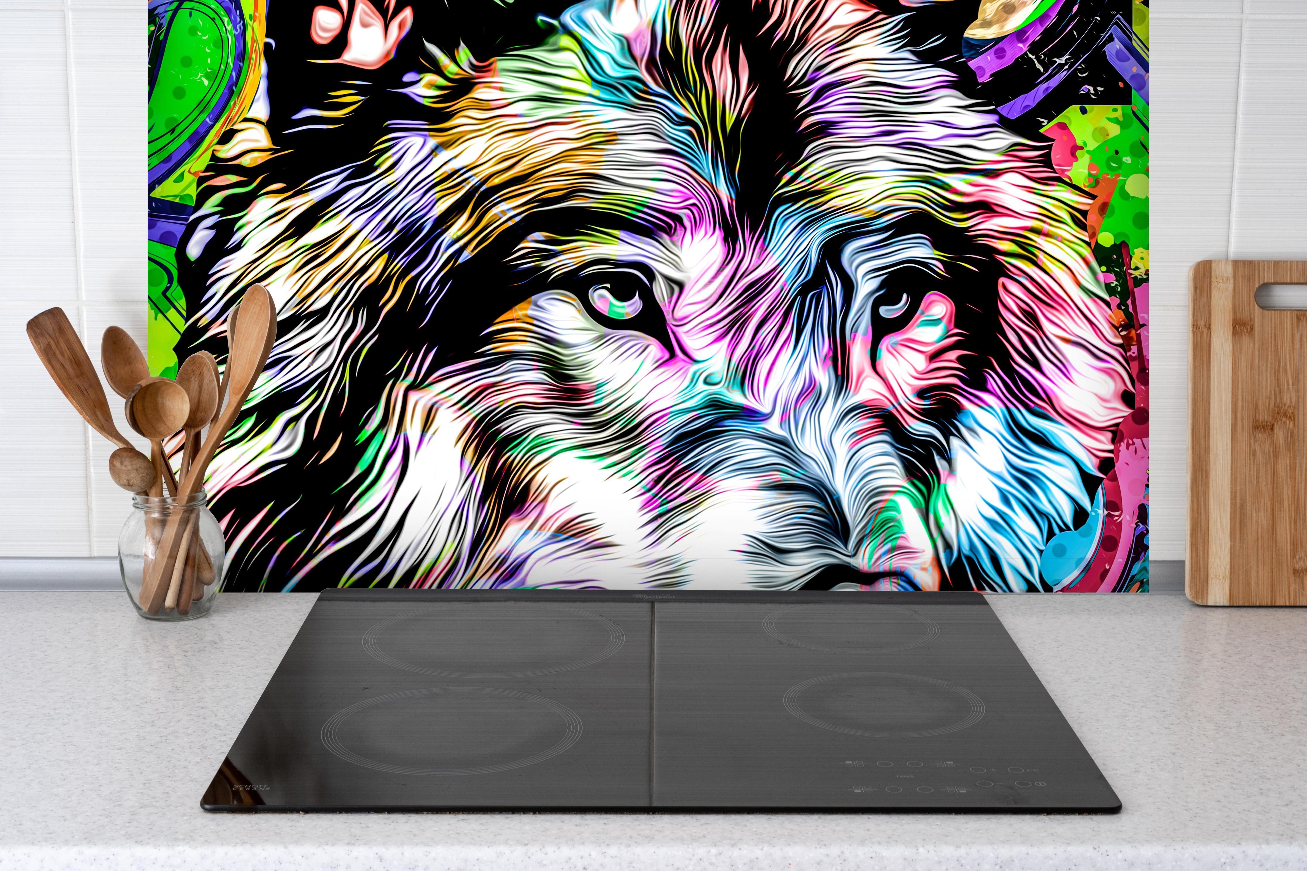 Spritzschutz - Bunter Wolfskopf mit abstrakten Elementen hinter einem Cerankochfeld zwischen Holz-Kochutensilien