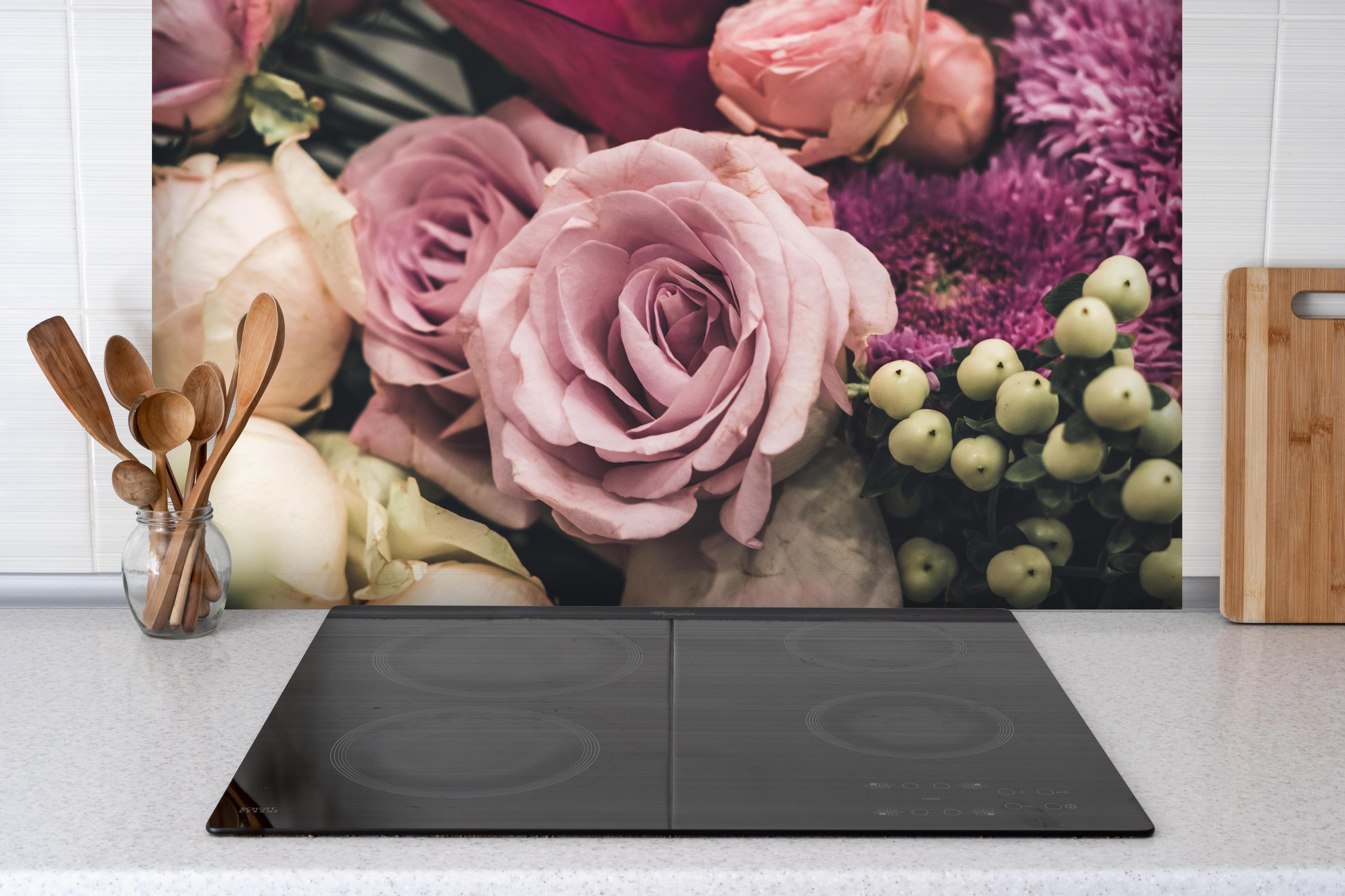 Spritzschutz - Buntes Blumenbouquet hinter einem Cerankochfeld zwischen Holz-Kochutensilien