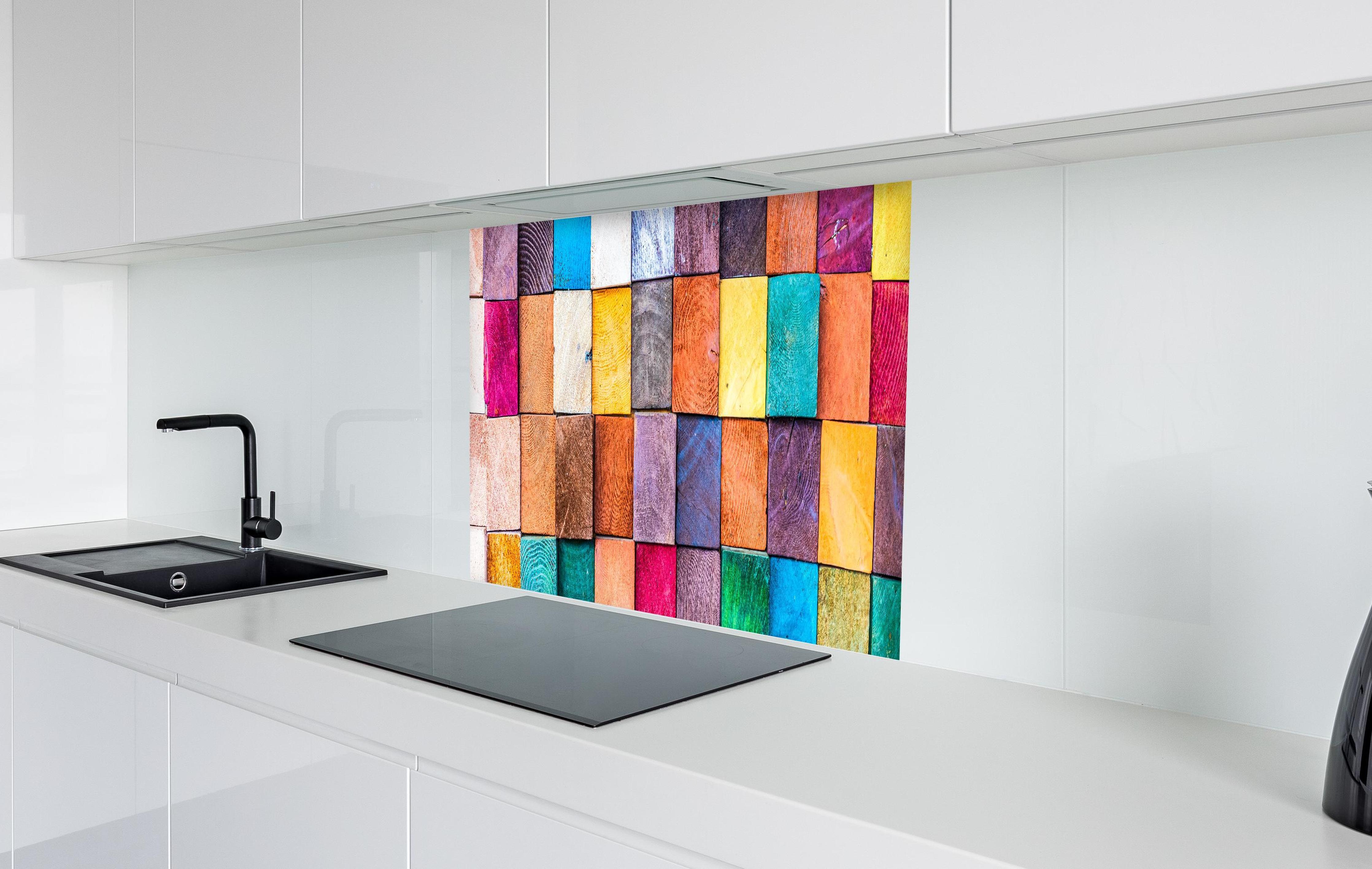 Spritzschutz - Buntes Holzstapelmuster in weißer Hochglanz-Küche hinter einem Cerankochfeld