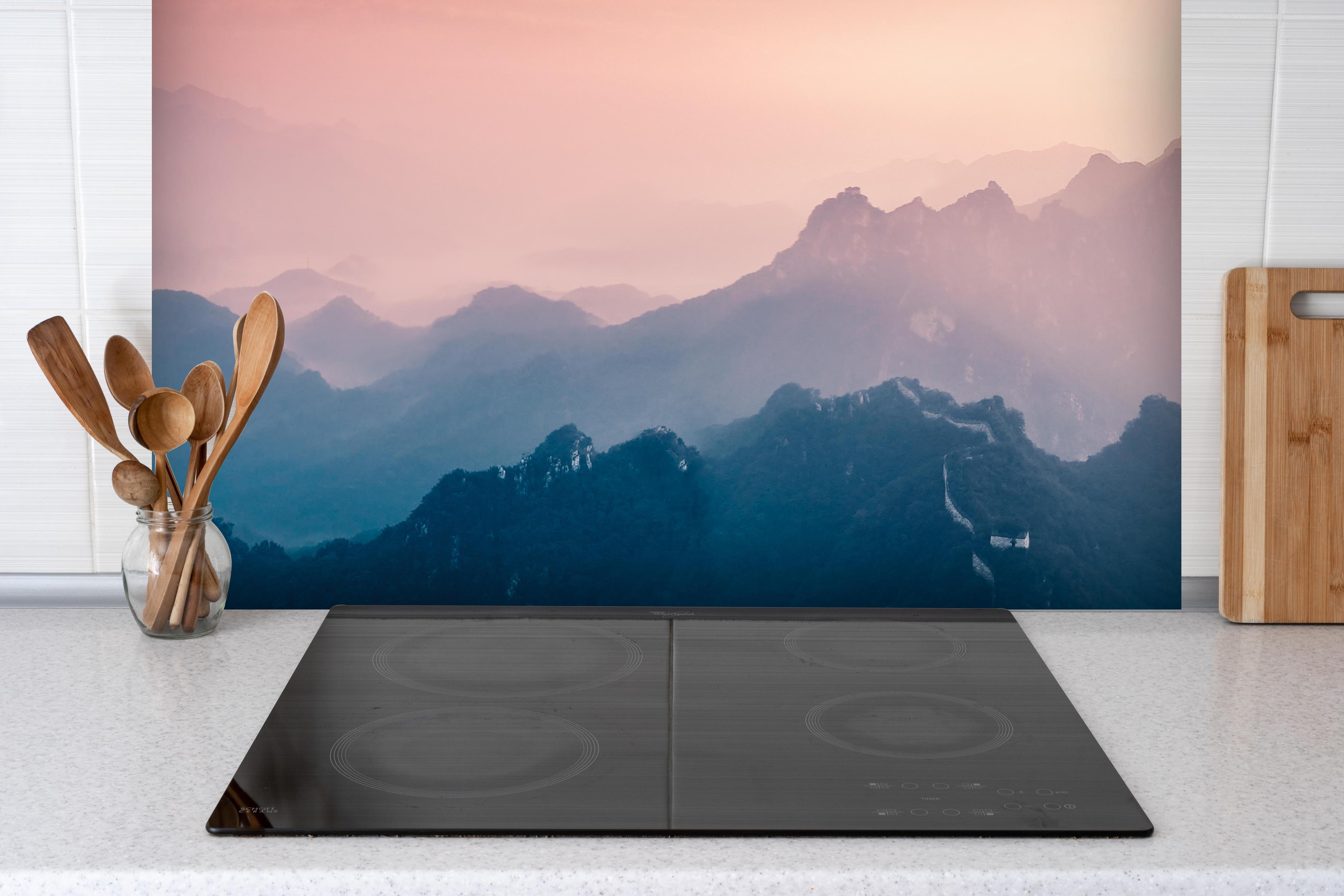 Spritzschutz - Chinesiche Mauer bei Sonnenuntergang hinter einem Cerankochfeld zwischen Holz-Kochutensilien