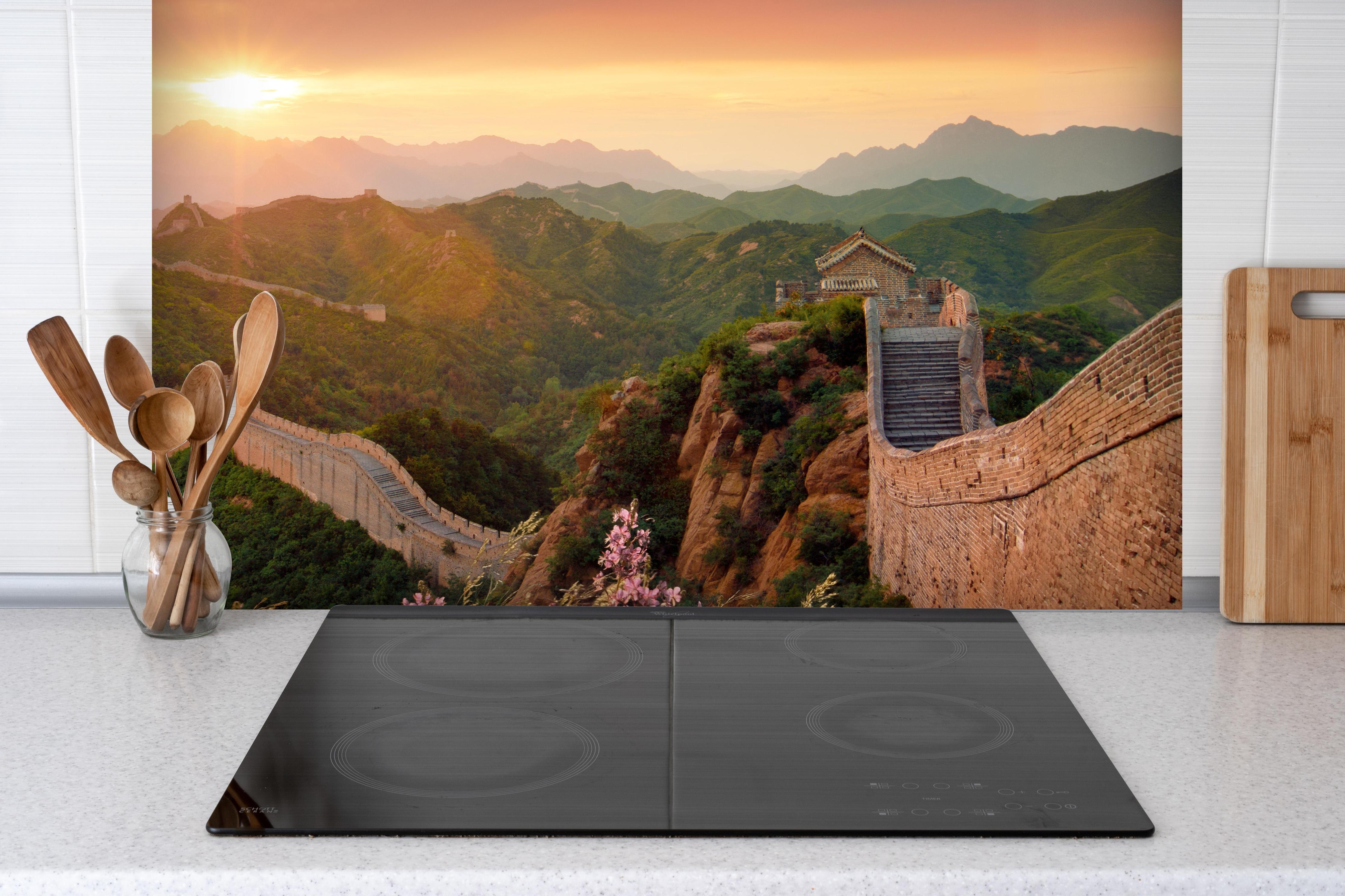 Spritzschutz - Chinesische Mauer bei Sonnenuntergang hinter einem Cerankochfeld zwischen Holz-Kochutensilien