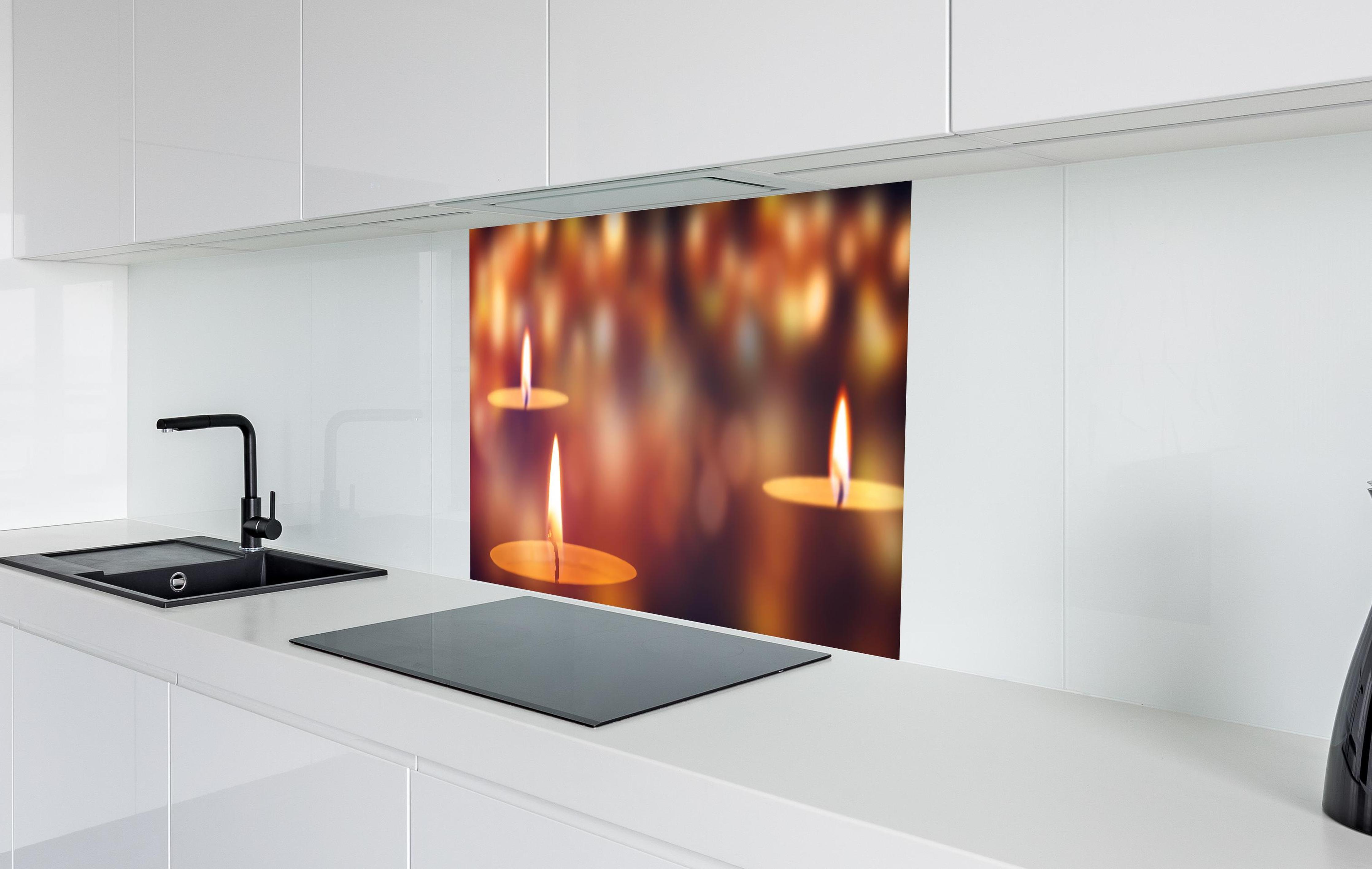 Spritzschutz - Den Teelichter bringen in weißer Hochglanz-Küche hinter einem Cerankochfeld