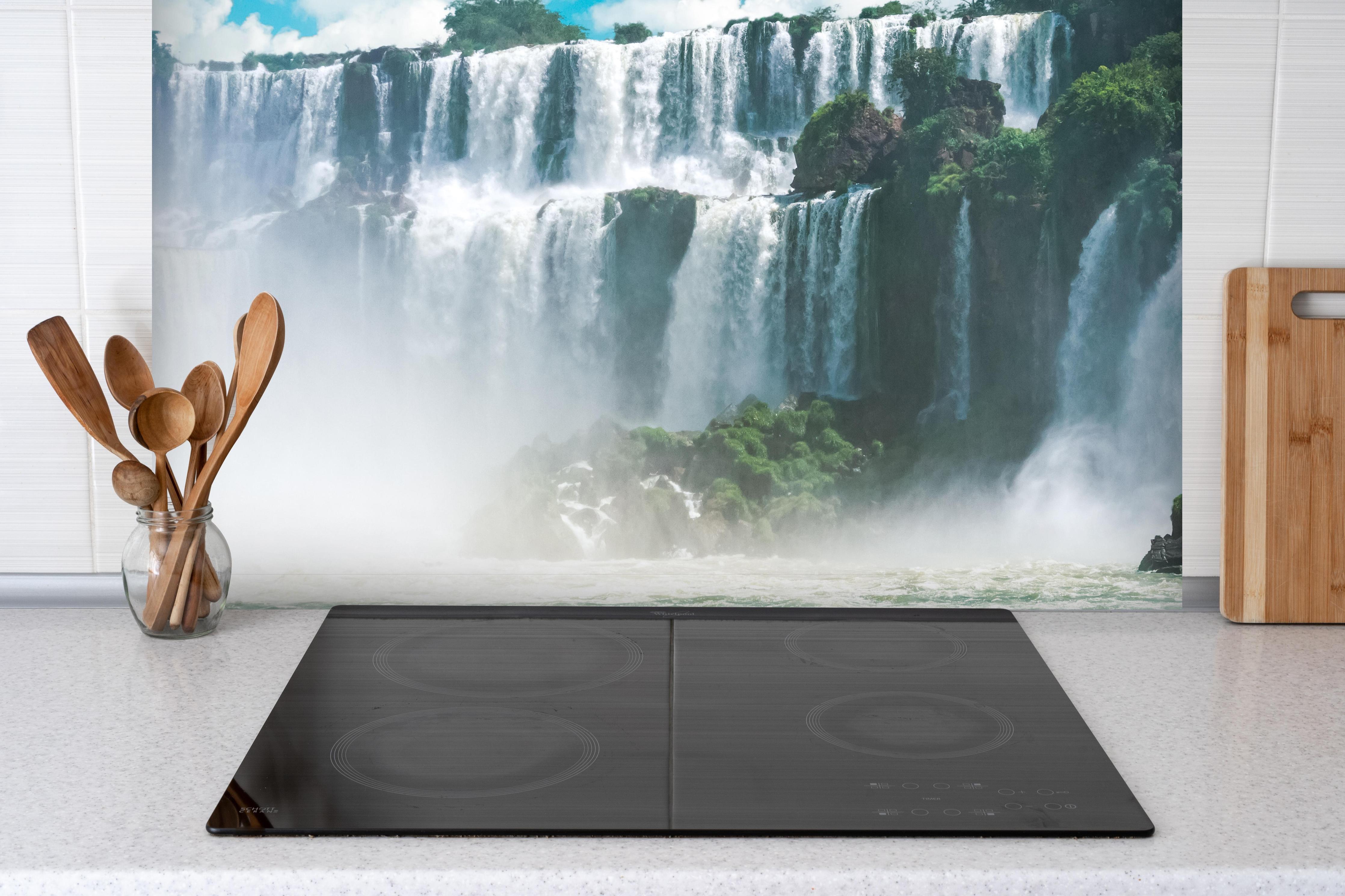 Spritzschutz - Die erstaunlichen Iguazu-Wasserfälle in Brasilien hinter einem Cerankochfeld zwischen Holz-Kochutensilien