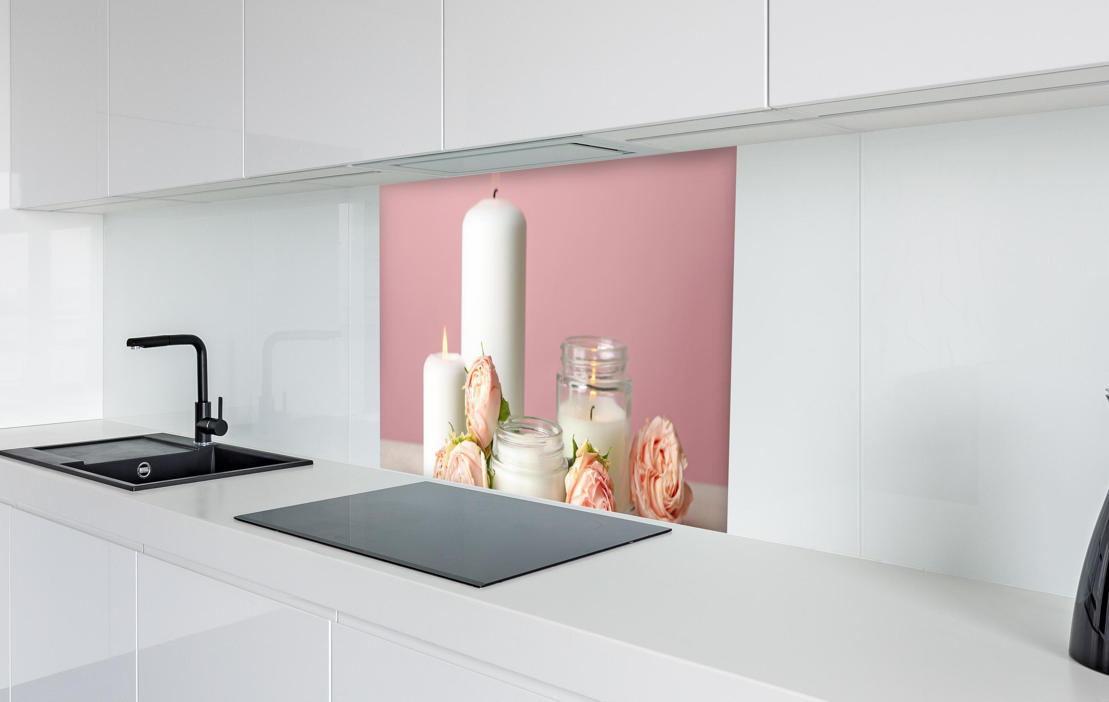 Spritzschutz - Duftkerzen und Rosen auf weißem Tisch in weißer Hochglanz-Küche hinter einem Cerankochfeld