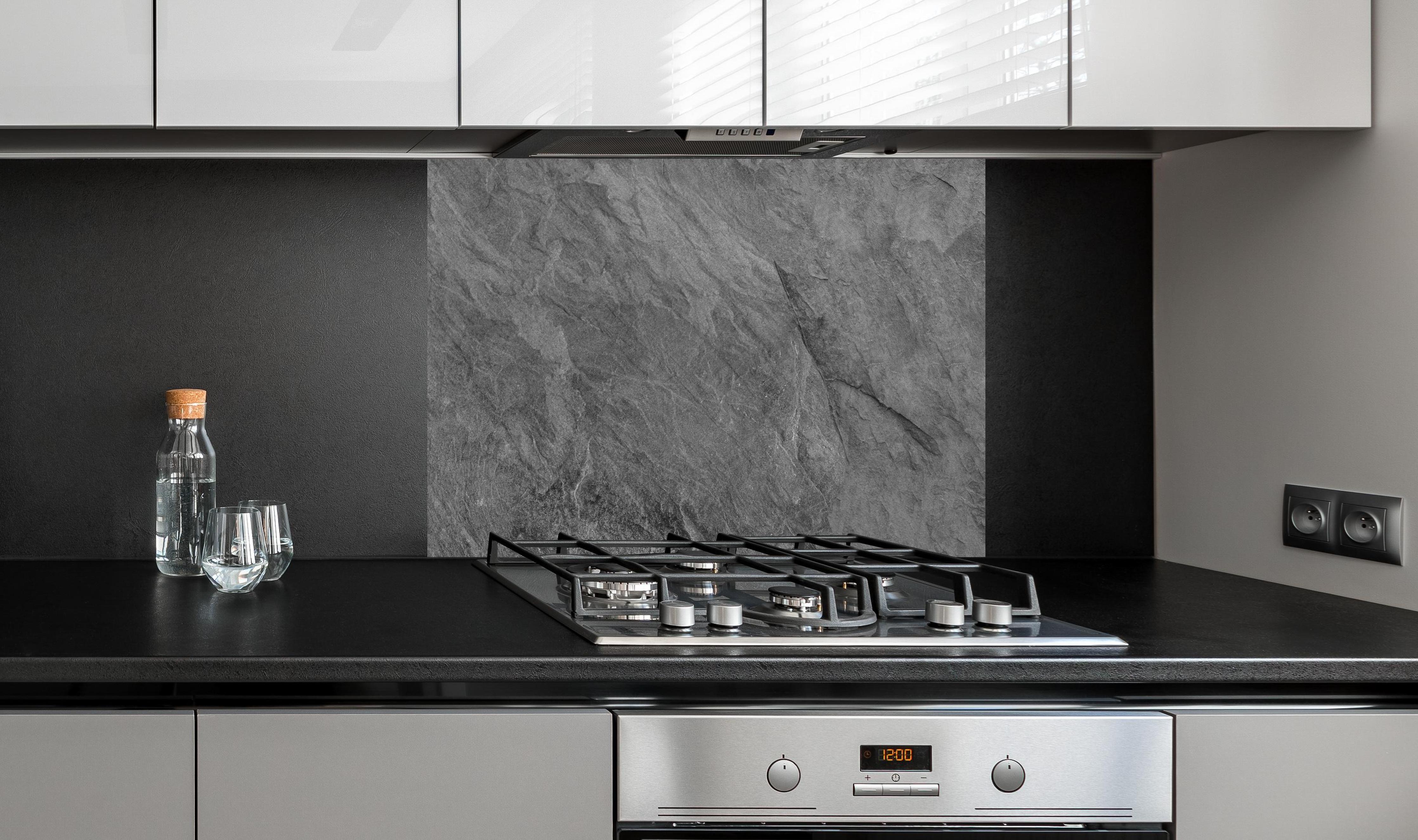 Spritzschutz - Dunkelgrauer Schiefer an edler Anthrazit-Wand hinter silbernem Gasherd