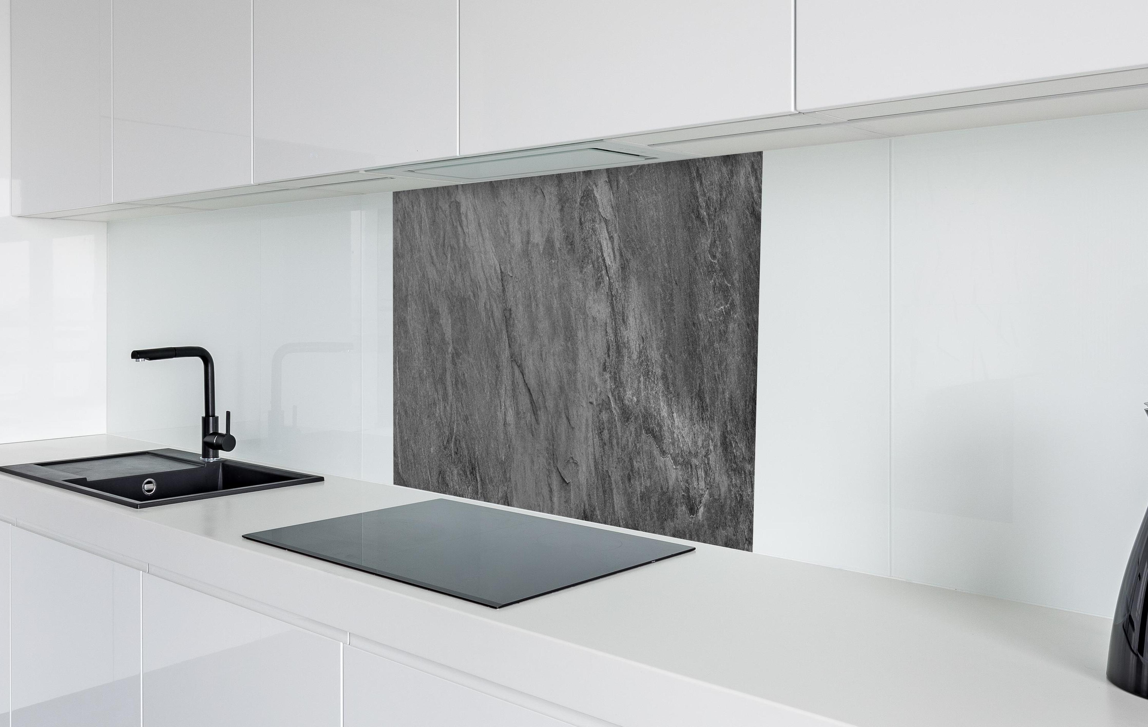 Spritzschutz - Dunkelgrauer Schiefer in weißer Hochglanz-Küche hinter einem Cerankochfeld