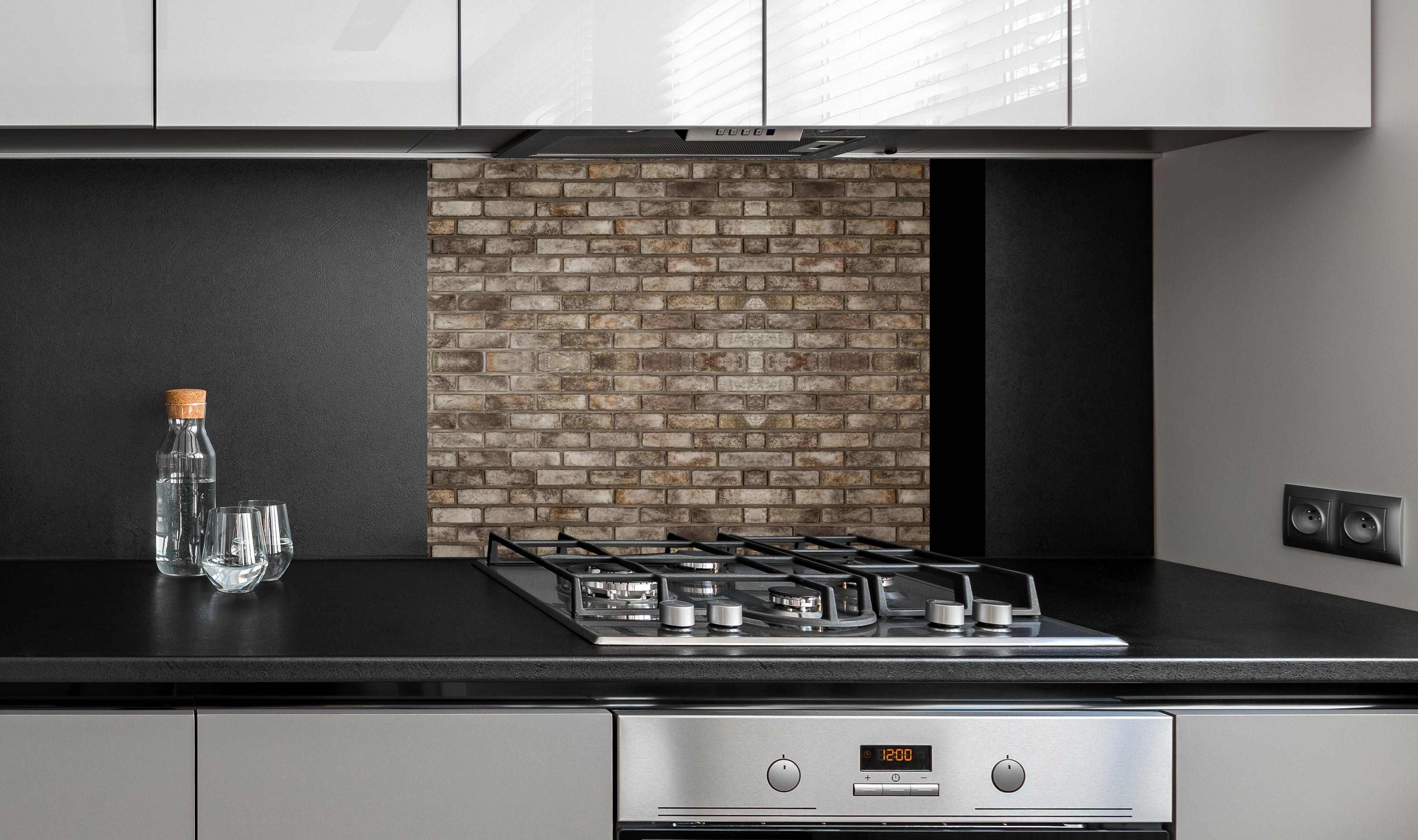 Spritzschutz - Dunkle Steinmauer an edler Anthrazit-Wand hinter silbernem Gasherd