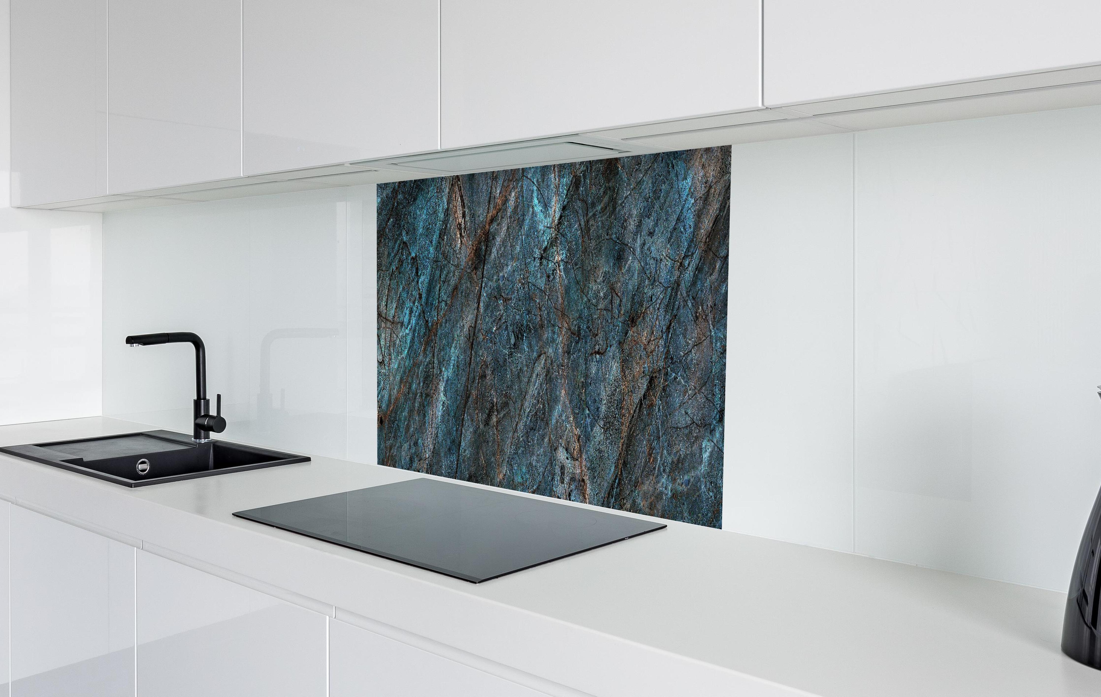Spritzschutz - Dunkler rustikaler Marmor - bläulich in weißer Hochglanz-Küche hinter einem Cerankochfeld