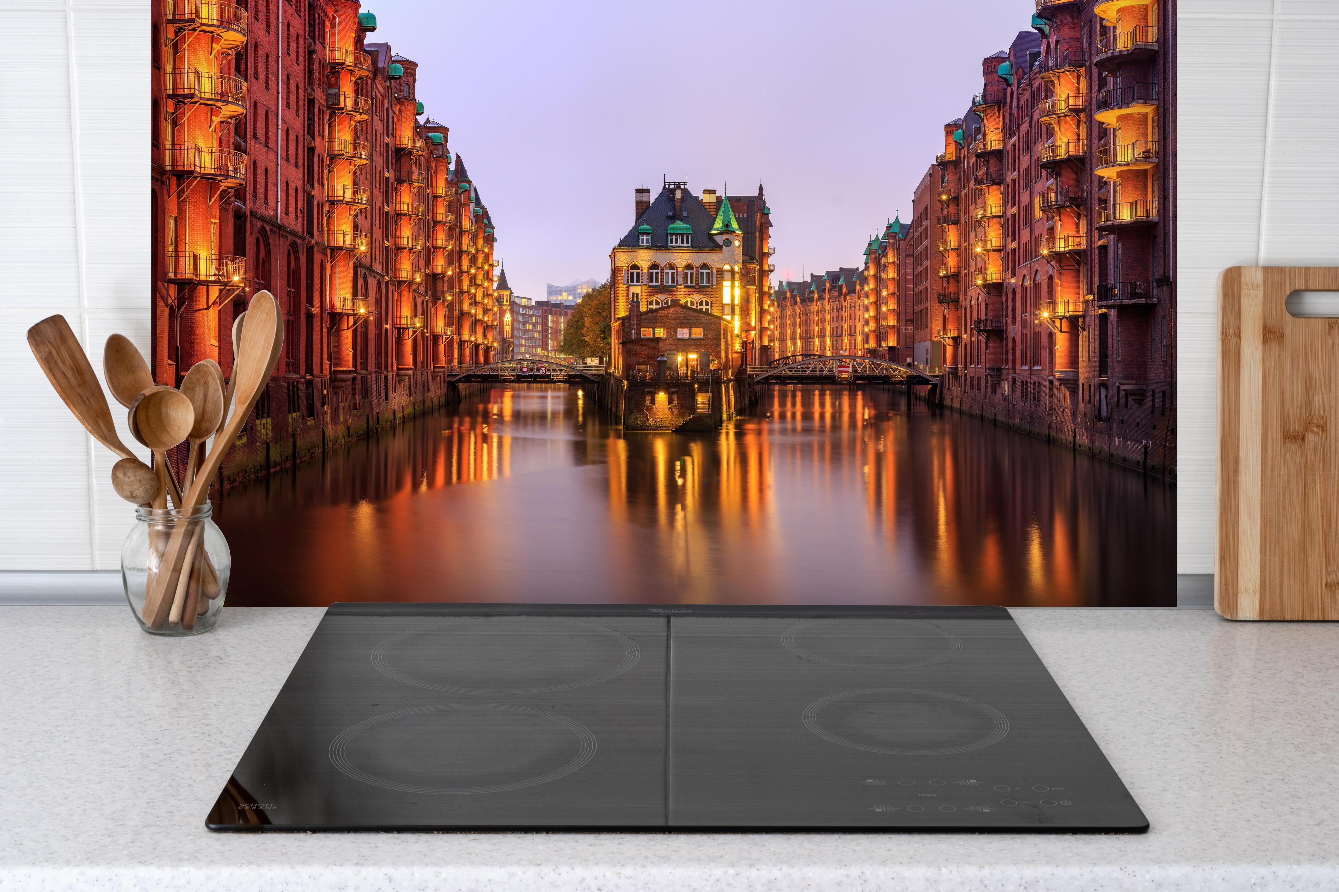 Spritzschutz - Elbe Hamburg im Nacht hinter einem Cerankochfeld zwischen Holz-Kochutensilien