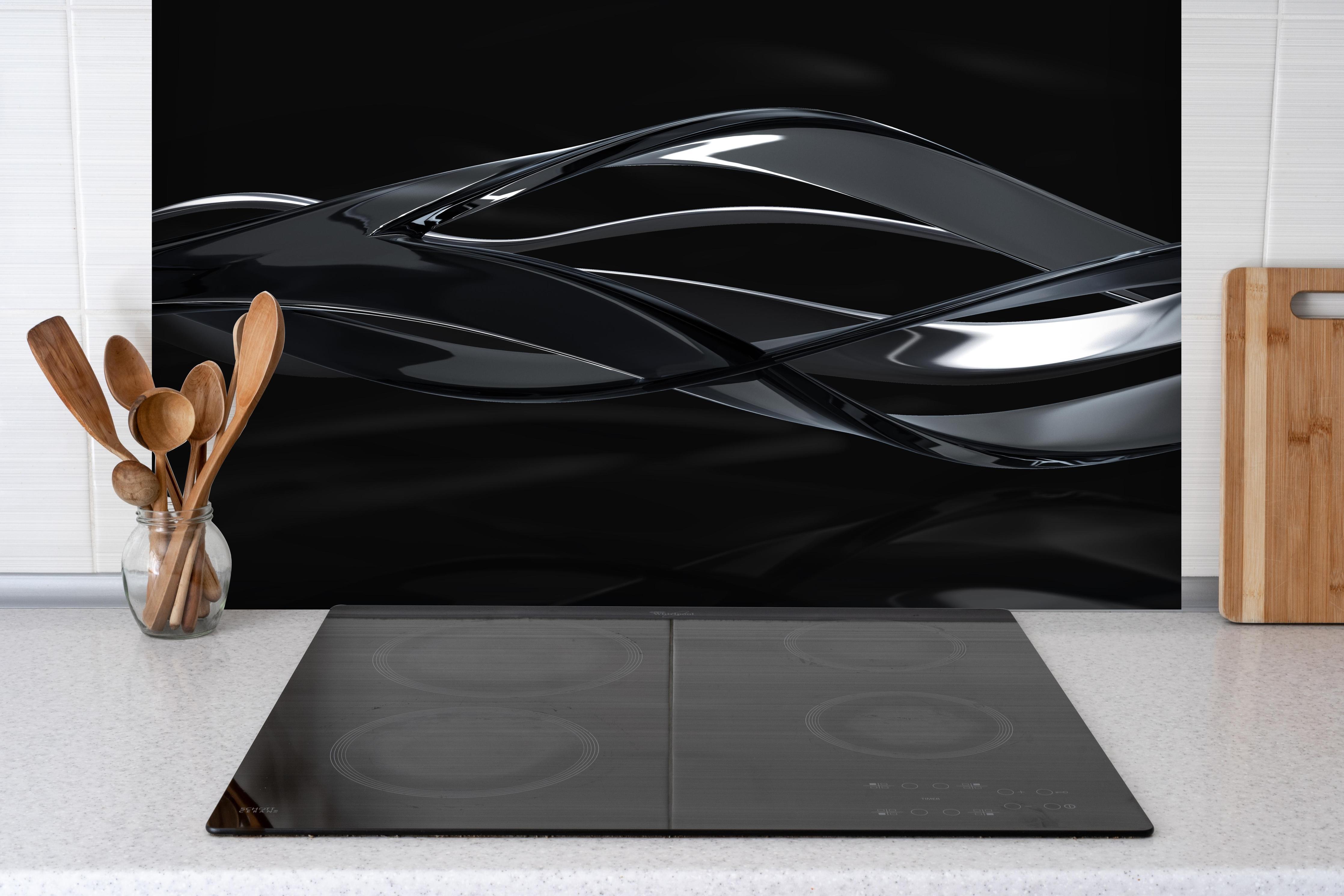 Spritzschutz - Elegant fließende Bewegung hinter einem Cerankochfeld zwischen Holz-Kochutensilien