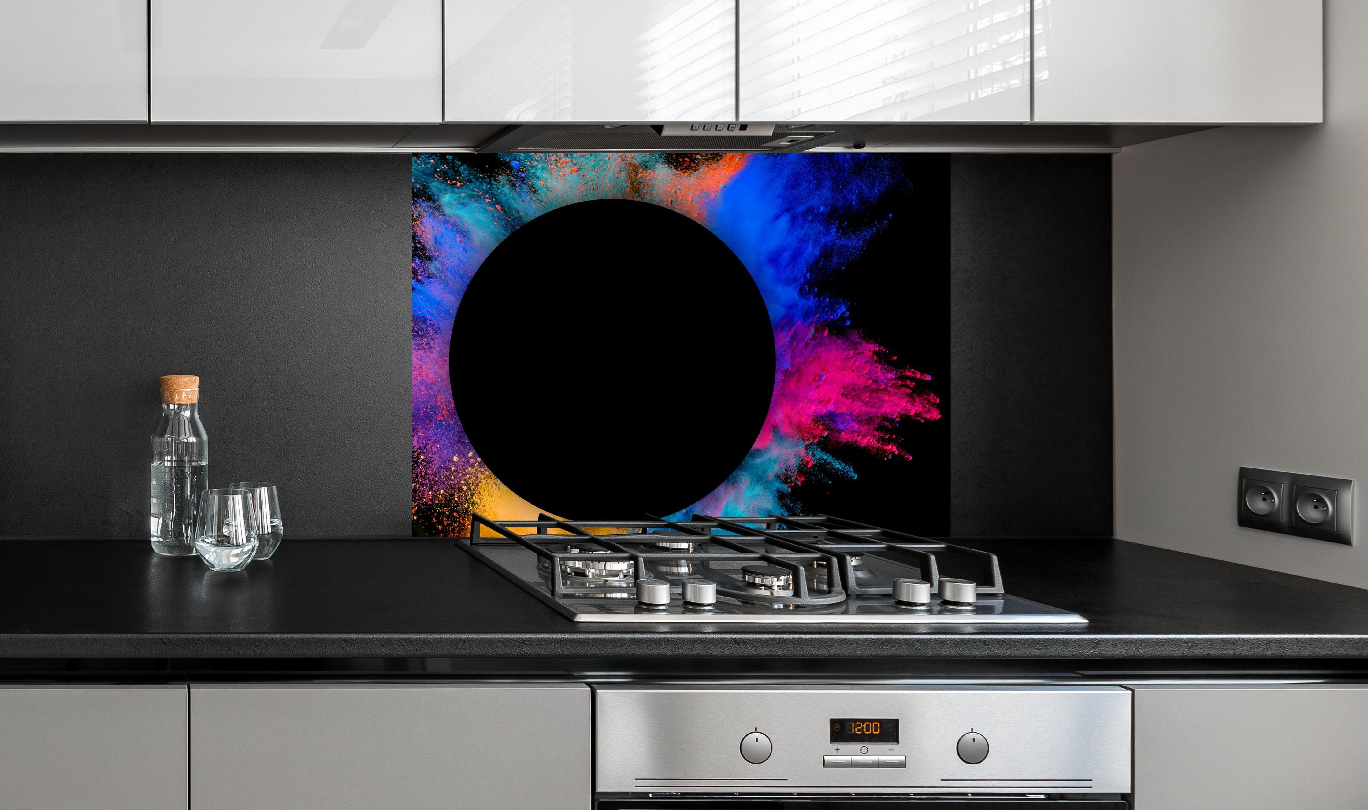 Spritzschutz - Explosion von farbigem Pulver mit schwarzem Kreis an edler Anthrazit-Wand hinter silbernem Gasherd