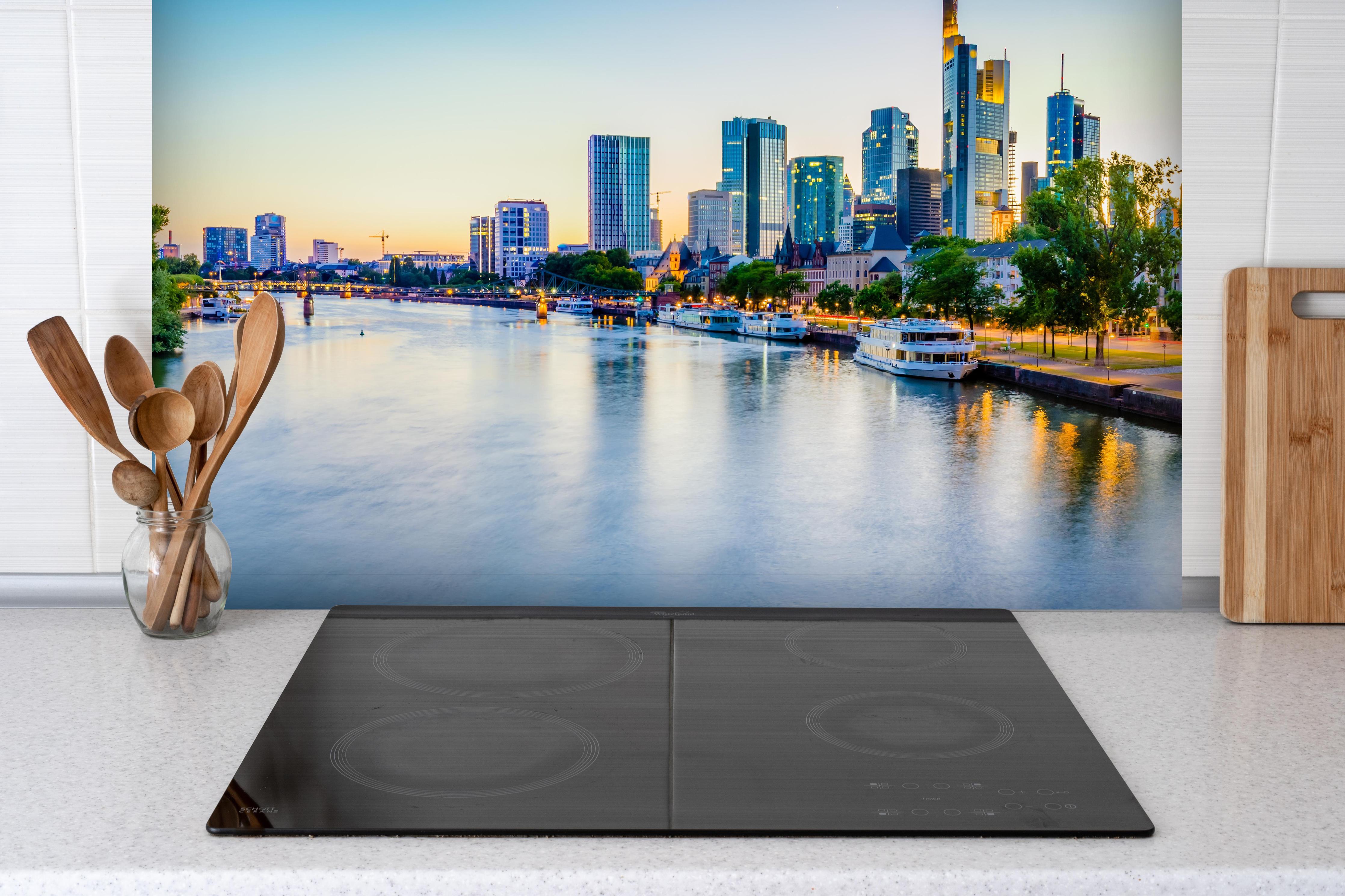 Spritzschutz - Frankfurt Panorama Ostend hinter einem Cerankochfeld zwischen Holz-Kochutensilien