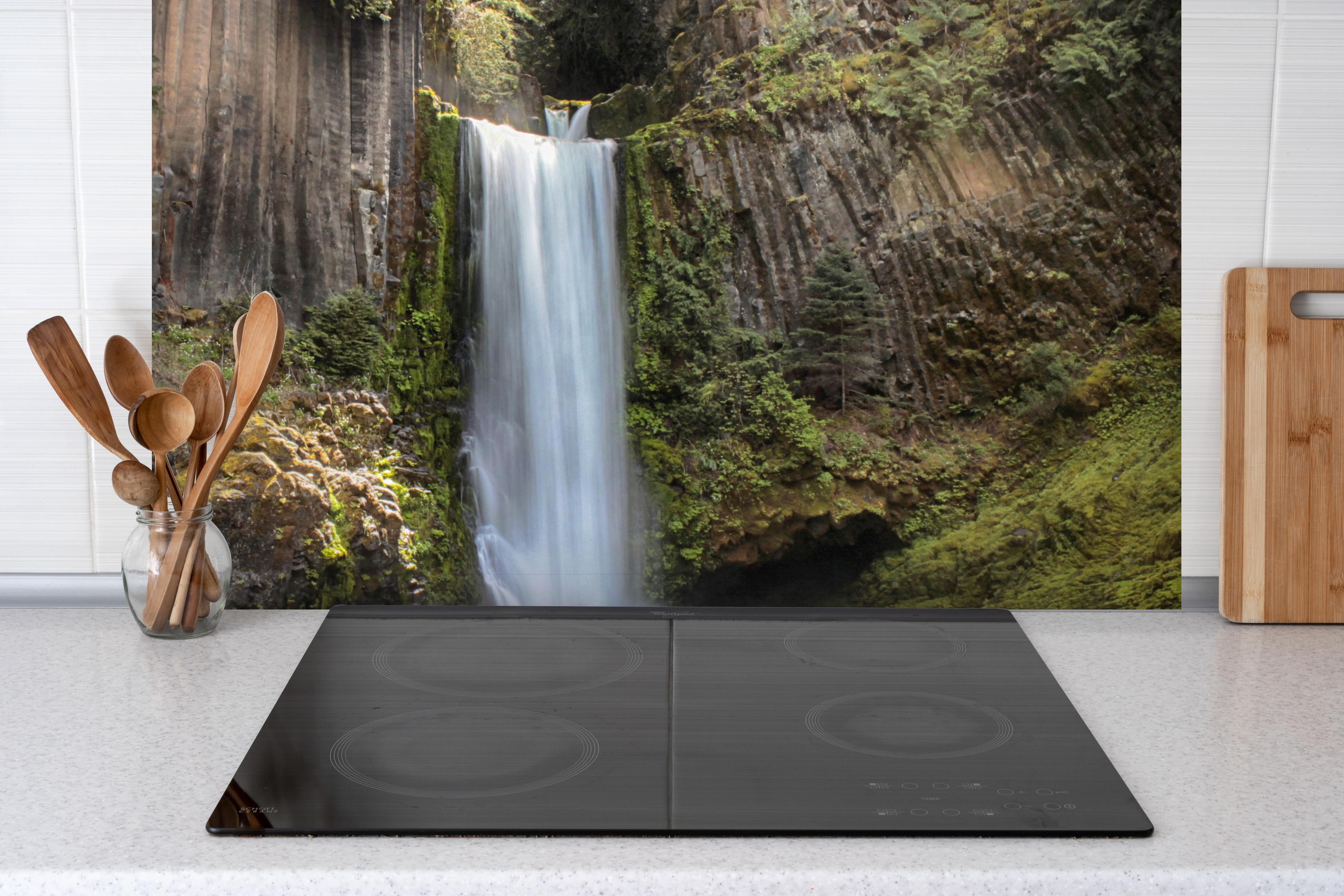 Spritzschutz - Friedliche Tokatee Falls hinter einem Cerankochfeld zwischen Holz-Kochutensilien
