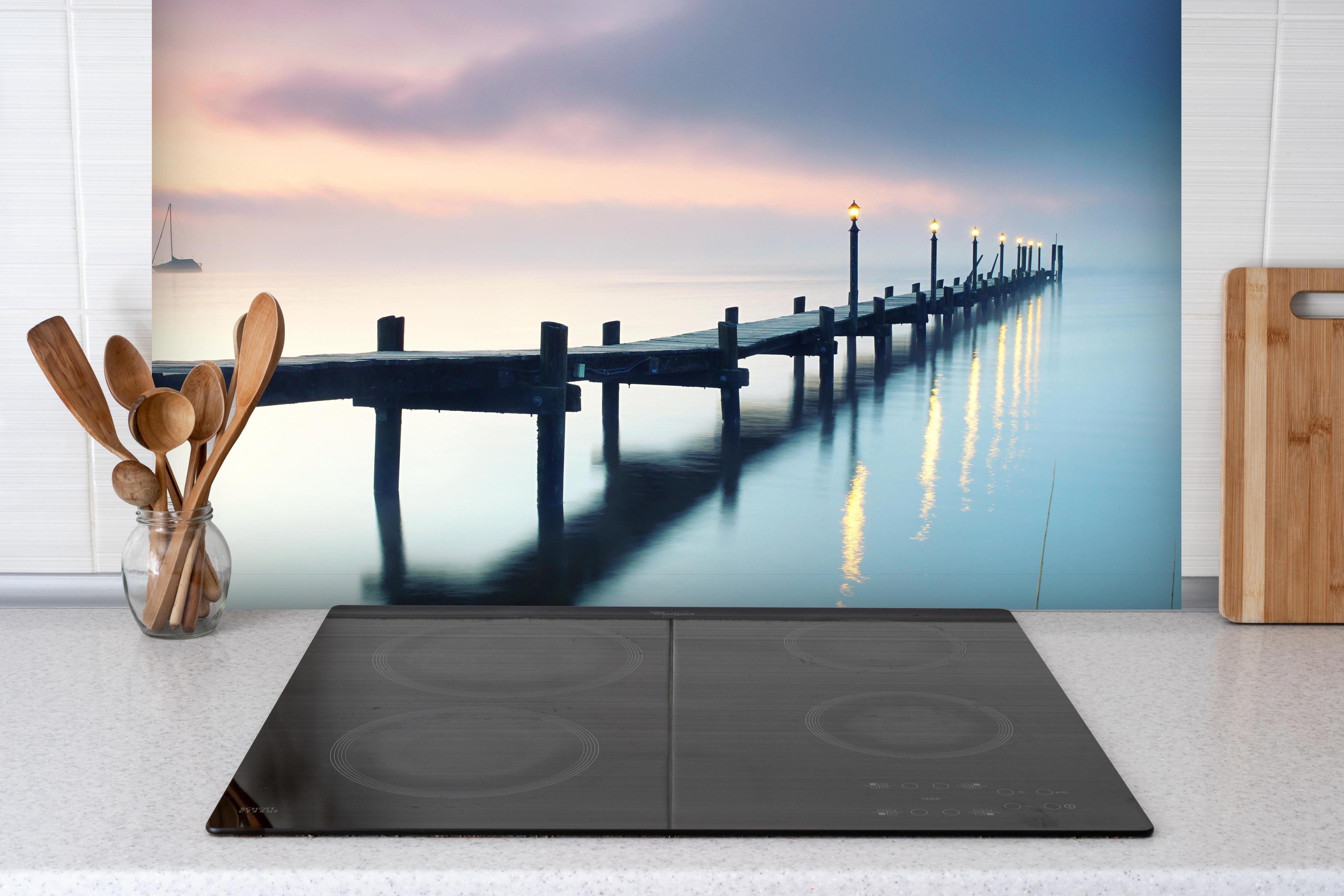 Spritzschutz - Friedlicher Meer Steg am Morgen hinter einem Cerankochfeld zwischen Holz-Kochutensilien