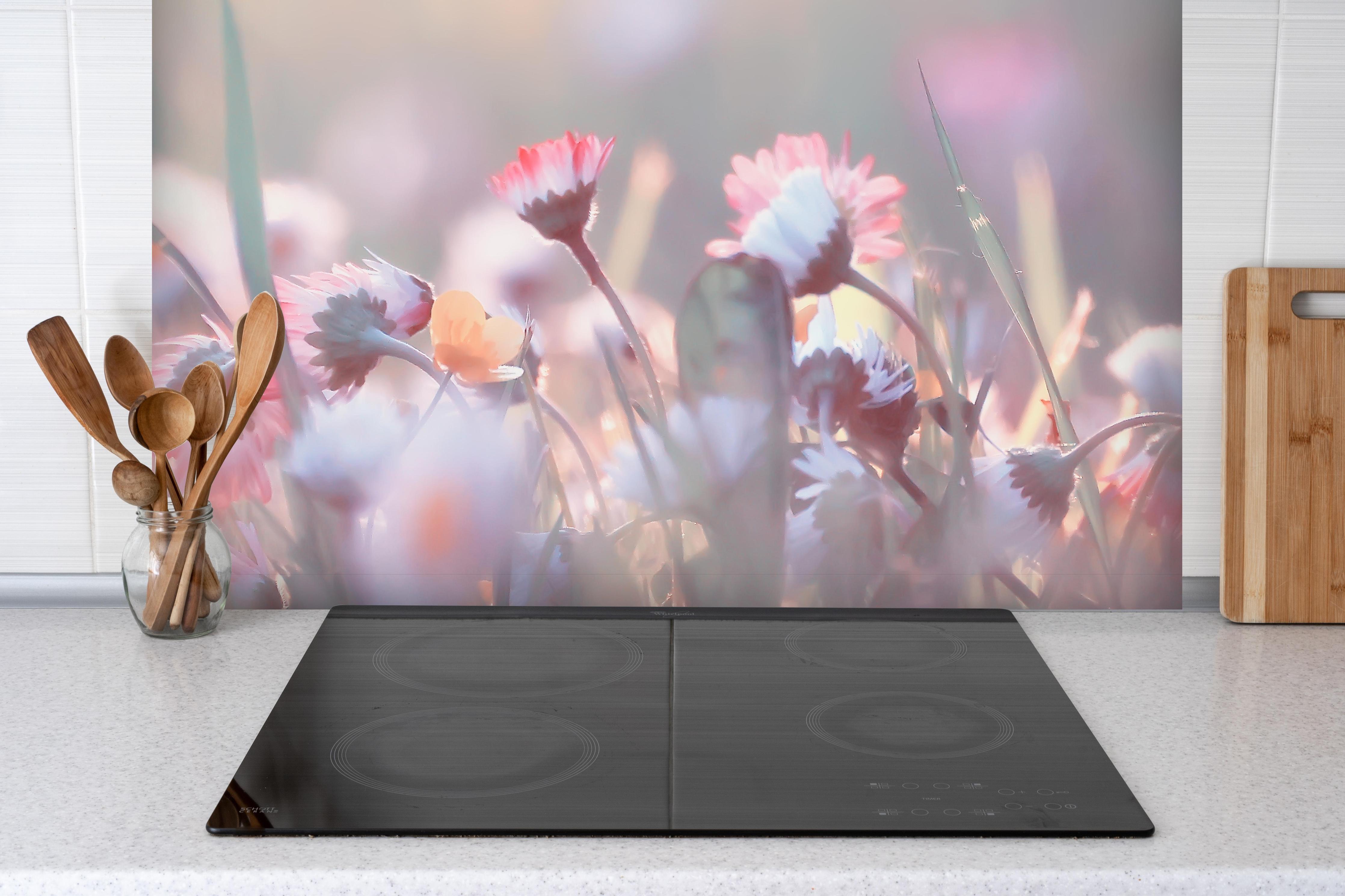 Spritzschutz - Gänseblümchen in der Natur hinter einem Cerankochfeld zwischen Holz-Kochutensilien