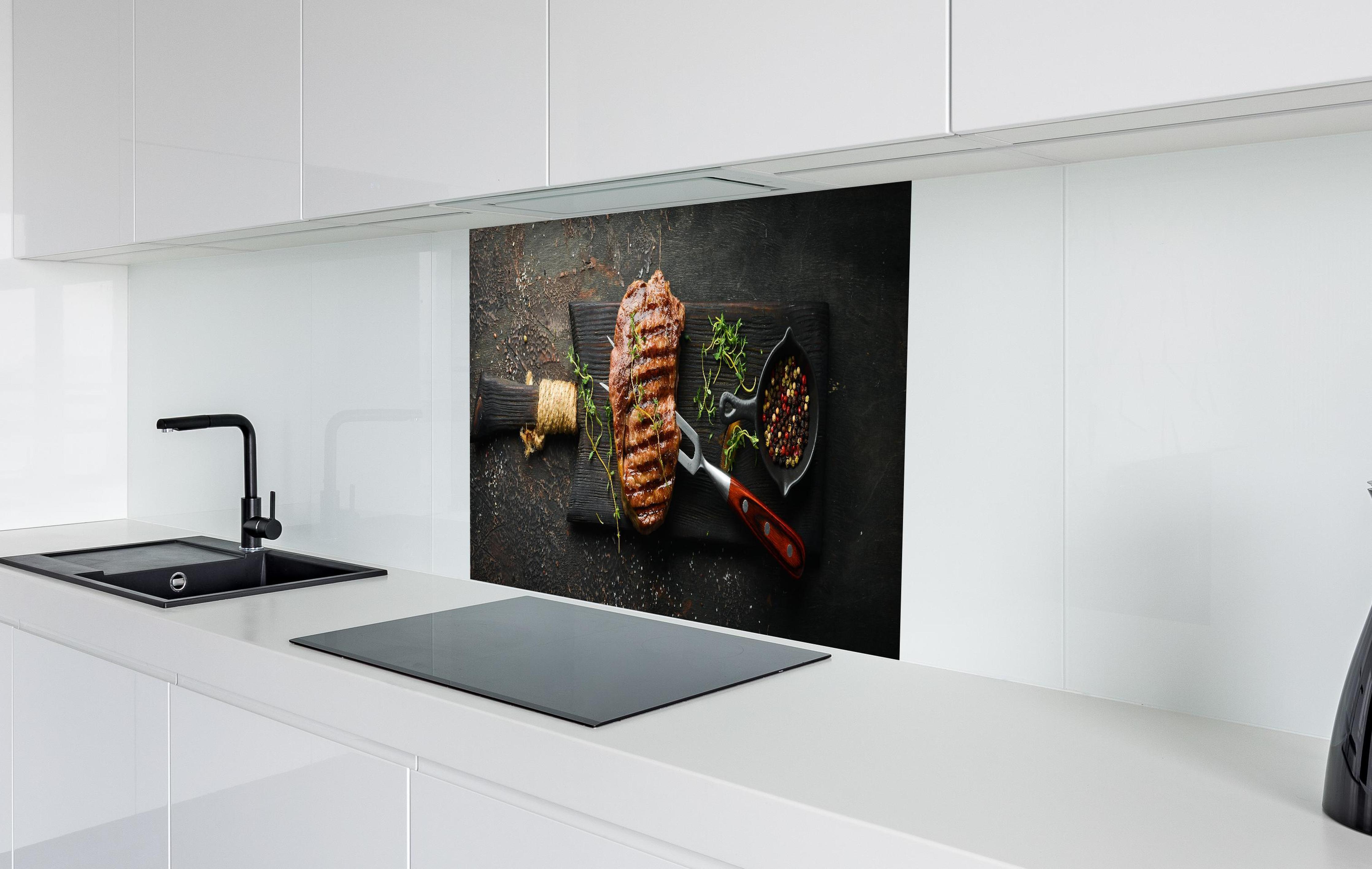 Spritzschutz - Gegrilltes Ribeye auf Holzplatte in weißer Hochglanz-Küche hinter einem Cerankochfeld