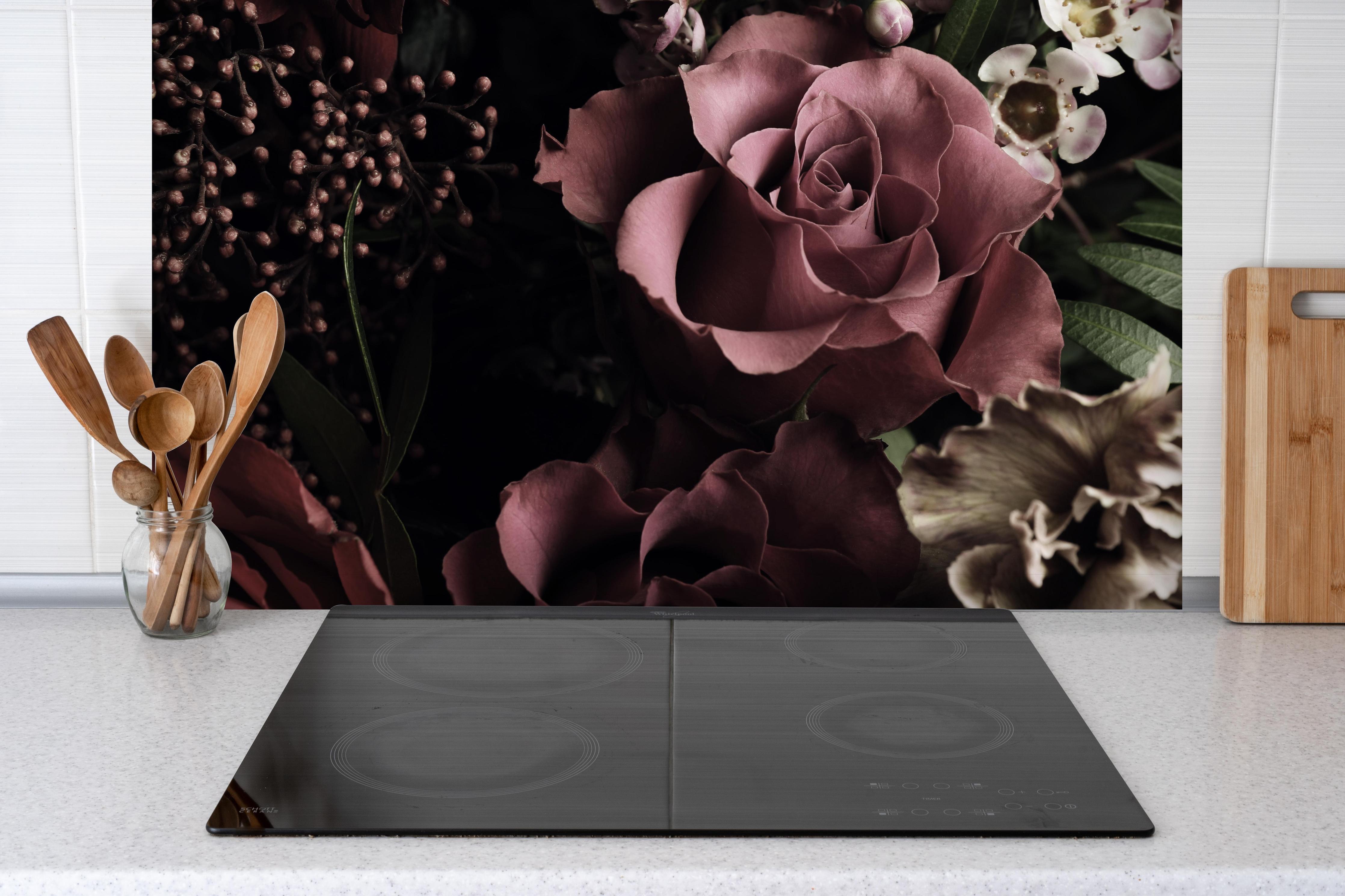 Spritzschutz - Gemischter Vintage-Blumenstrauß hinter einem Cerankochfeld zwischen Holz-Kochutensilien