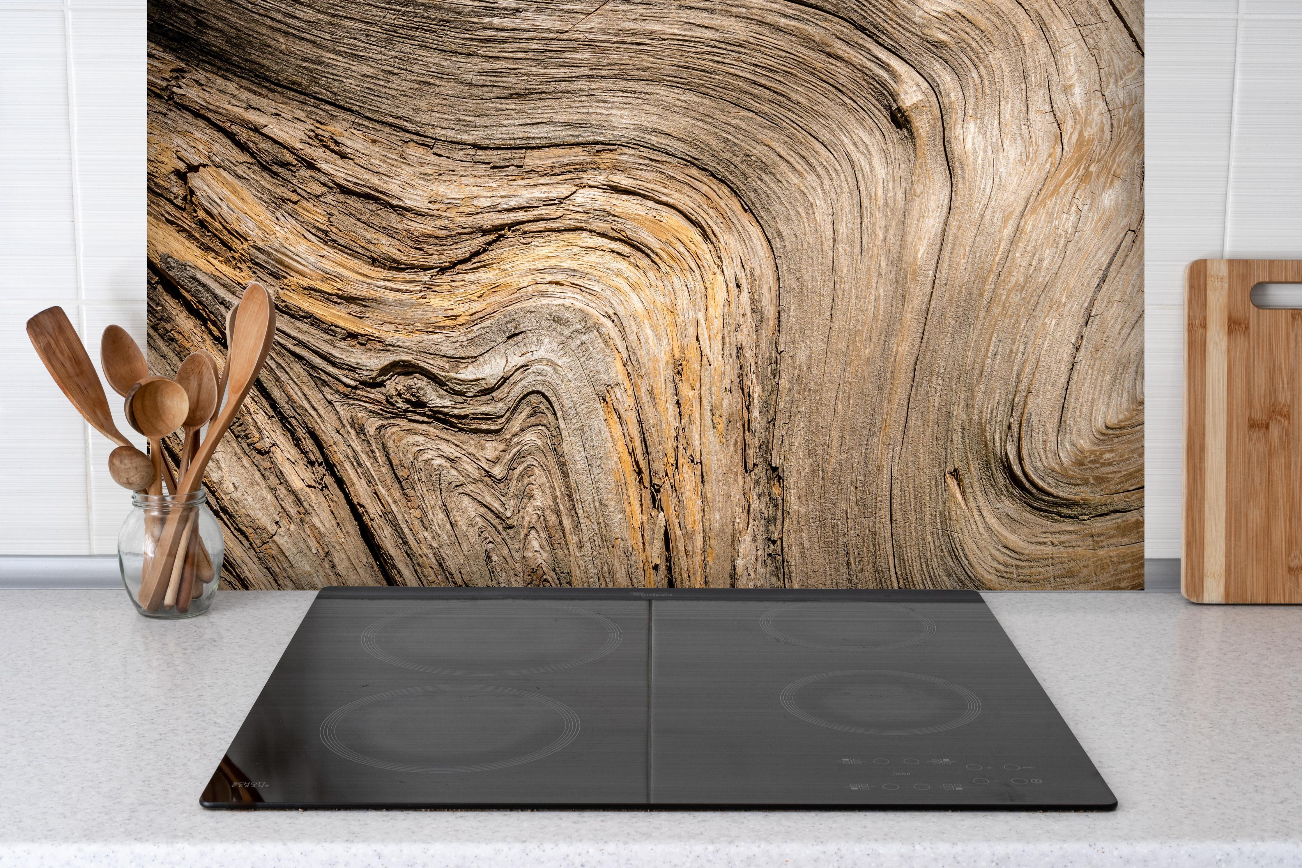 Spritzschutz - Geschwungenes Naturholz hinter einem Cerankochfeld zwischen Holz-Kochutensilien