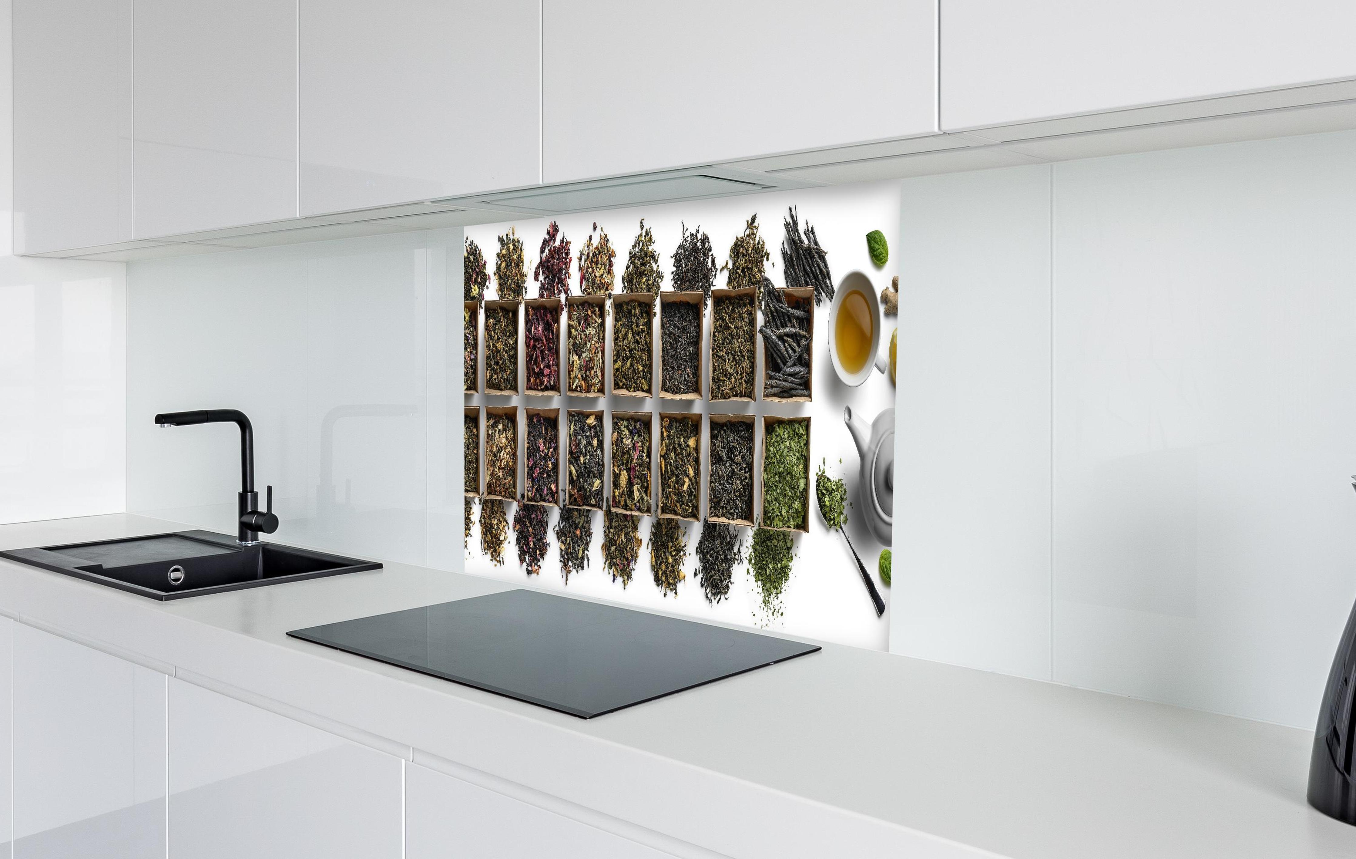 Spritzschutz - Gesunde Teesorten in weißer Hochglanz-Küche hinter einem Cerankochfeld