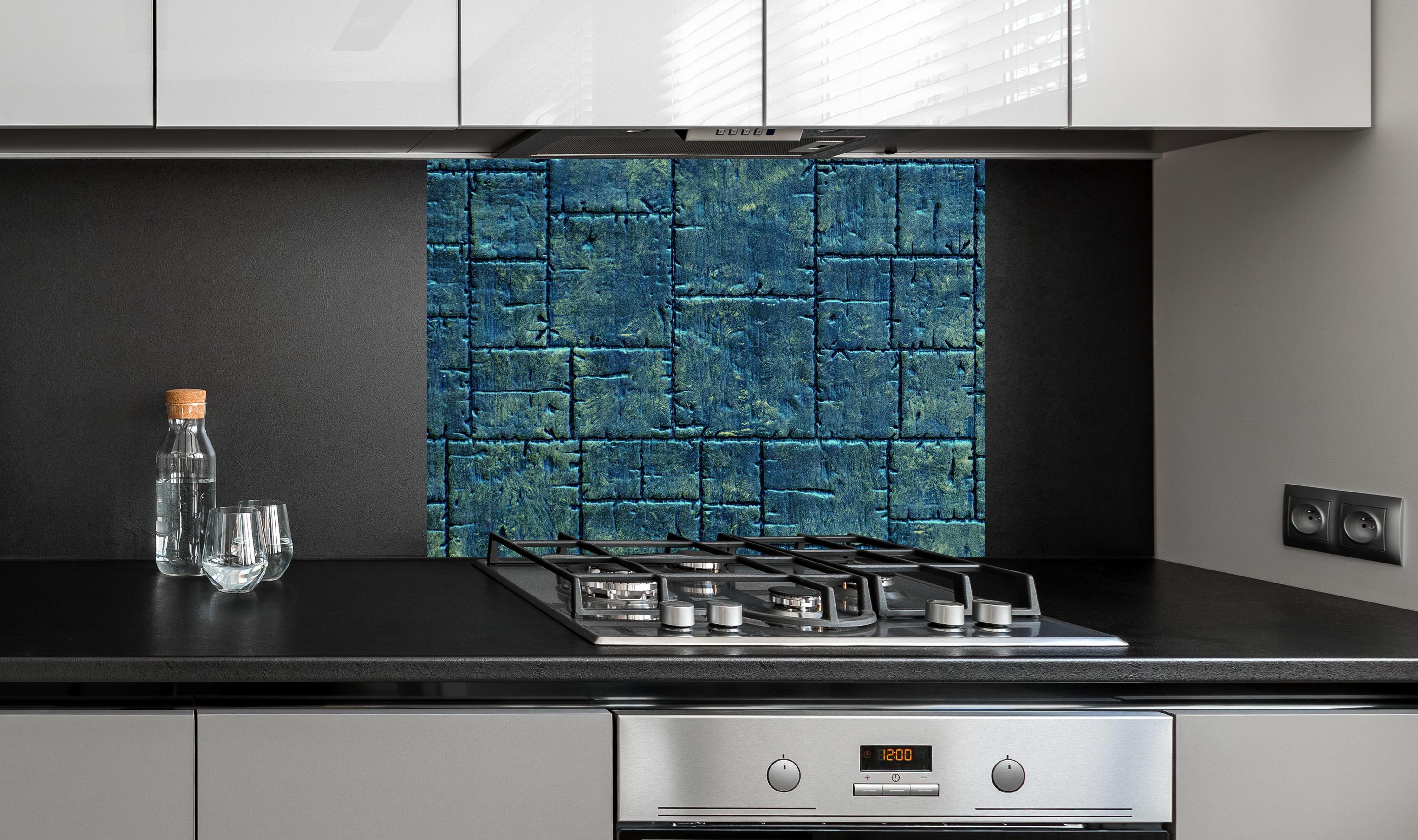 Spritzschutz - Glänzende Fliese in gelblichem Schimmer an edler Anthrazit-Wand hinter silbernem Gasherd