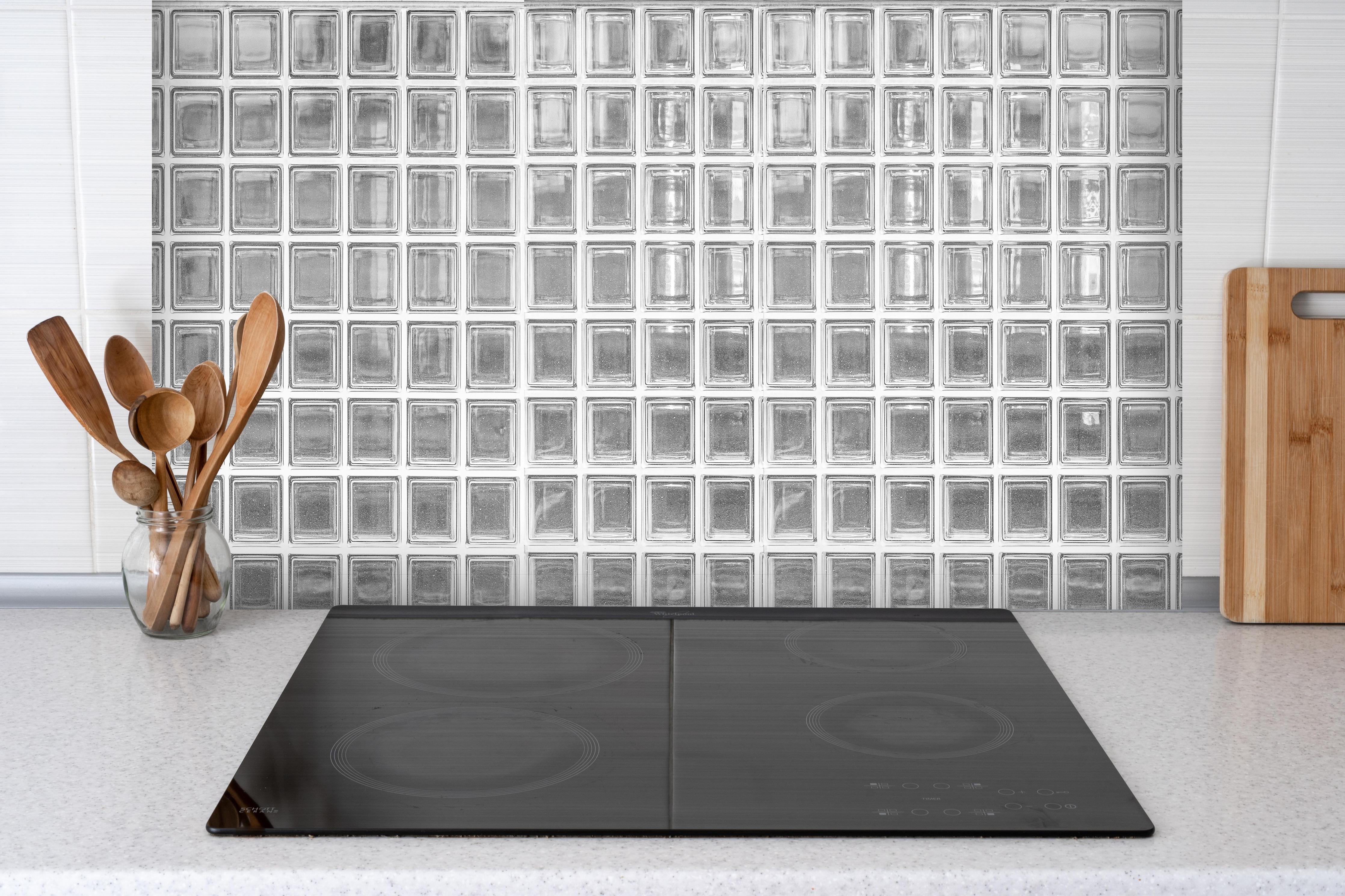 Spritzschutz - Glaswand hinter einem Cerankochfeld zwischen Holz-Kochutensilien