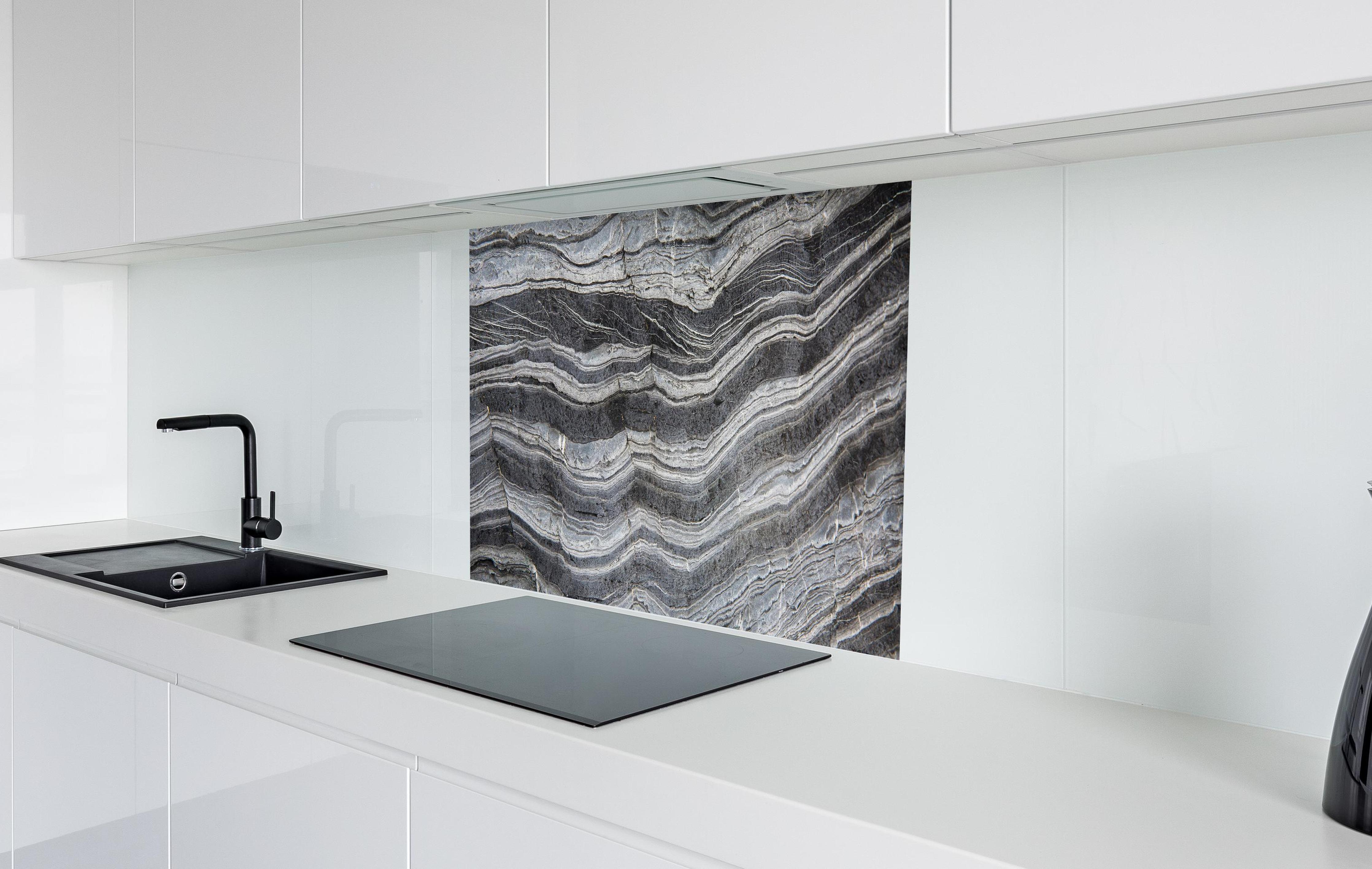 Spritzschutz - Gräulicher rissiger Schiefer in weißer Hochglanz-Küche hinter einem Cerankochfeld