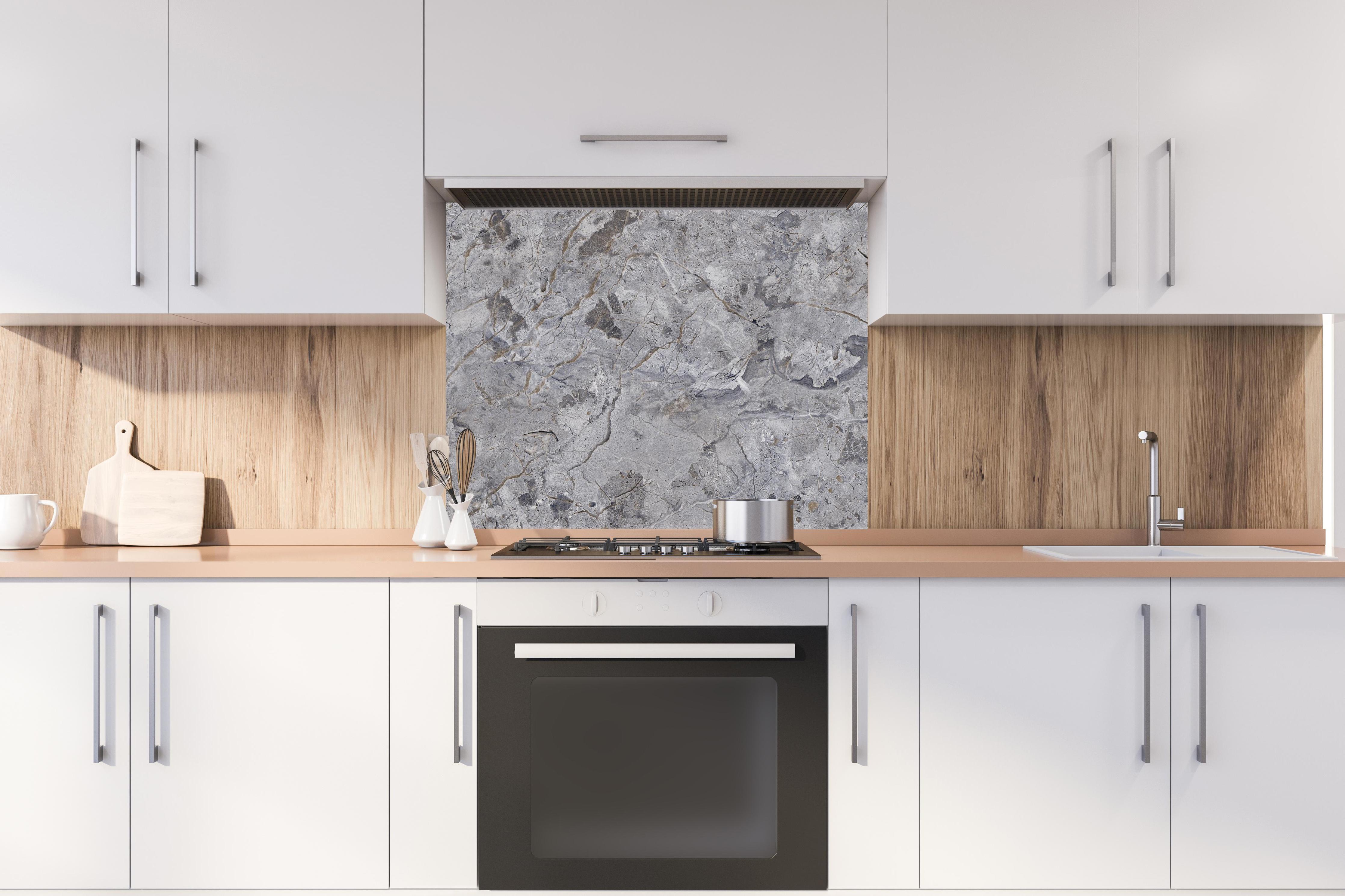 Spritzschutz - Grauer Marmor hinter stilvollem Gasherd unter Dunstabzugshaube