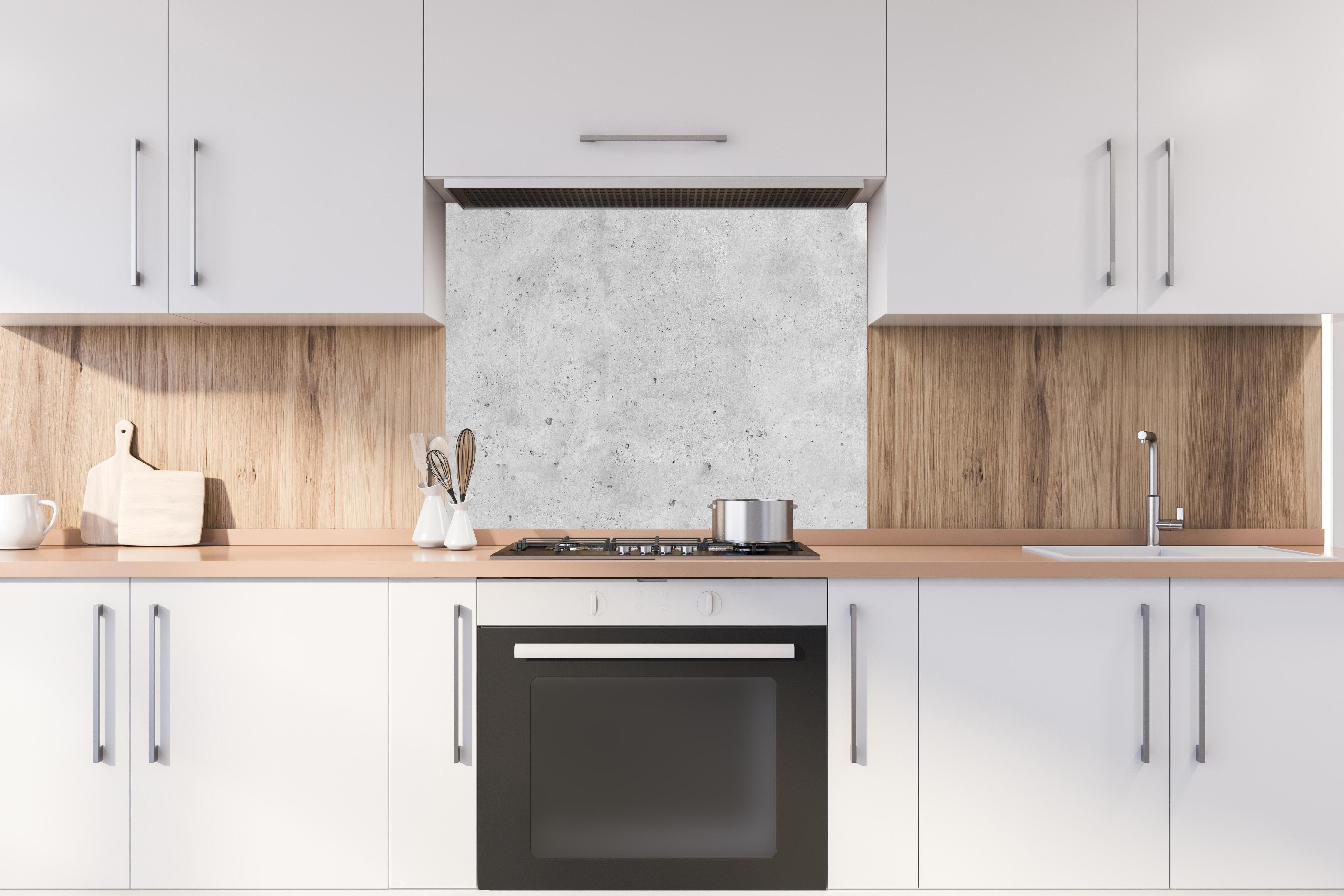 Spritzschutz - Grauer rauer Beton hinter stilvollem Gasherd unter Dunstabzugshaube