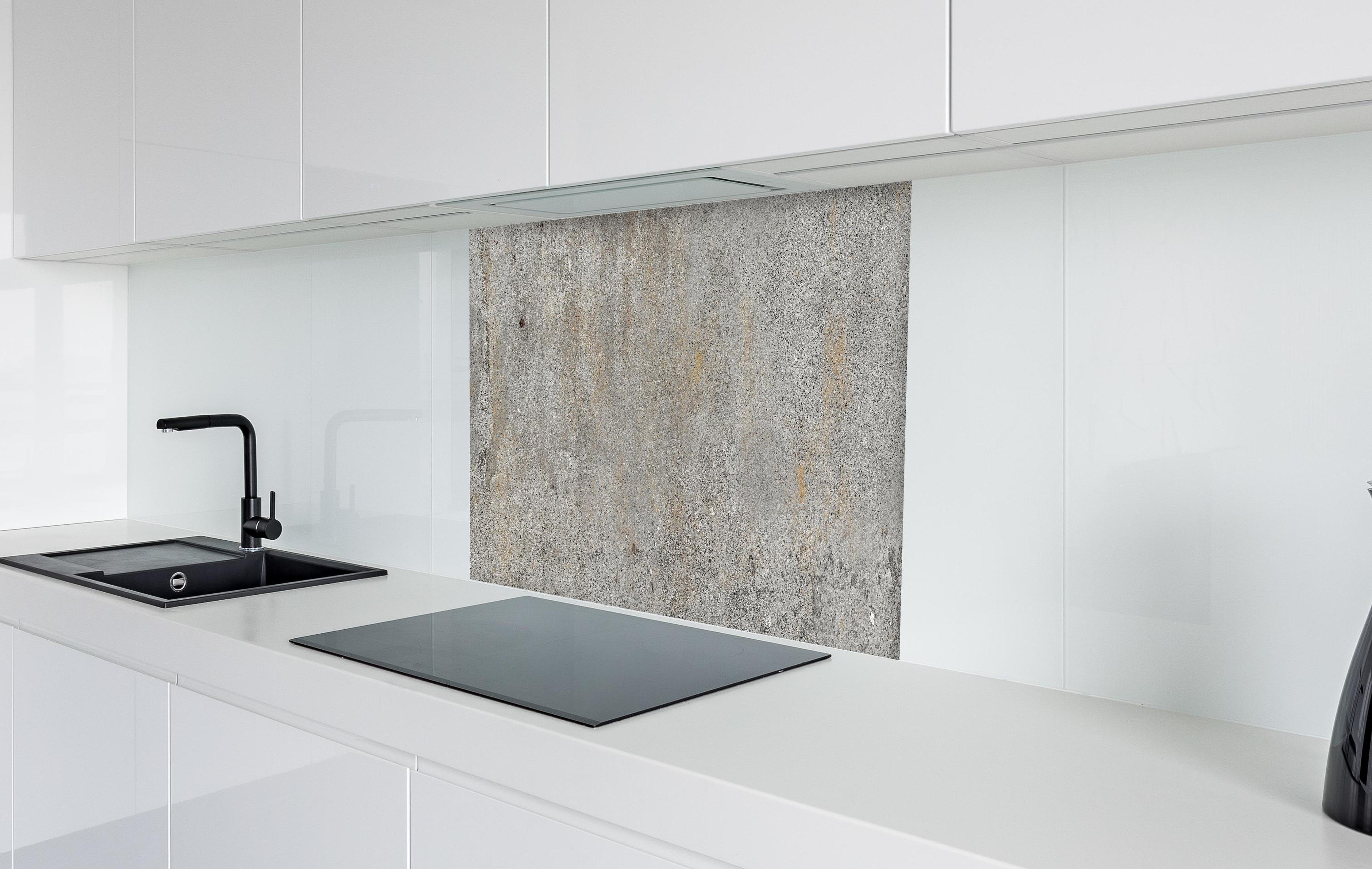 Spritzschutz - Grauer rustikaler Beton in weißer Hochglanz-Küche hinter einem Cerankochfeld