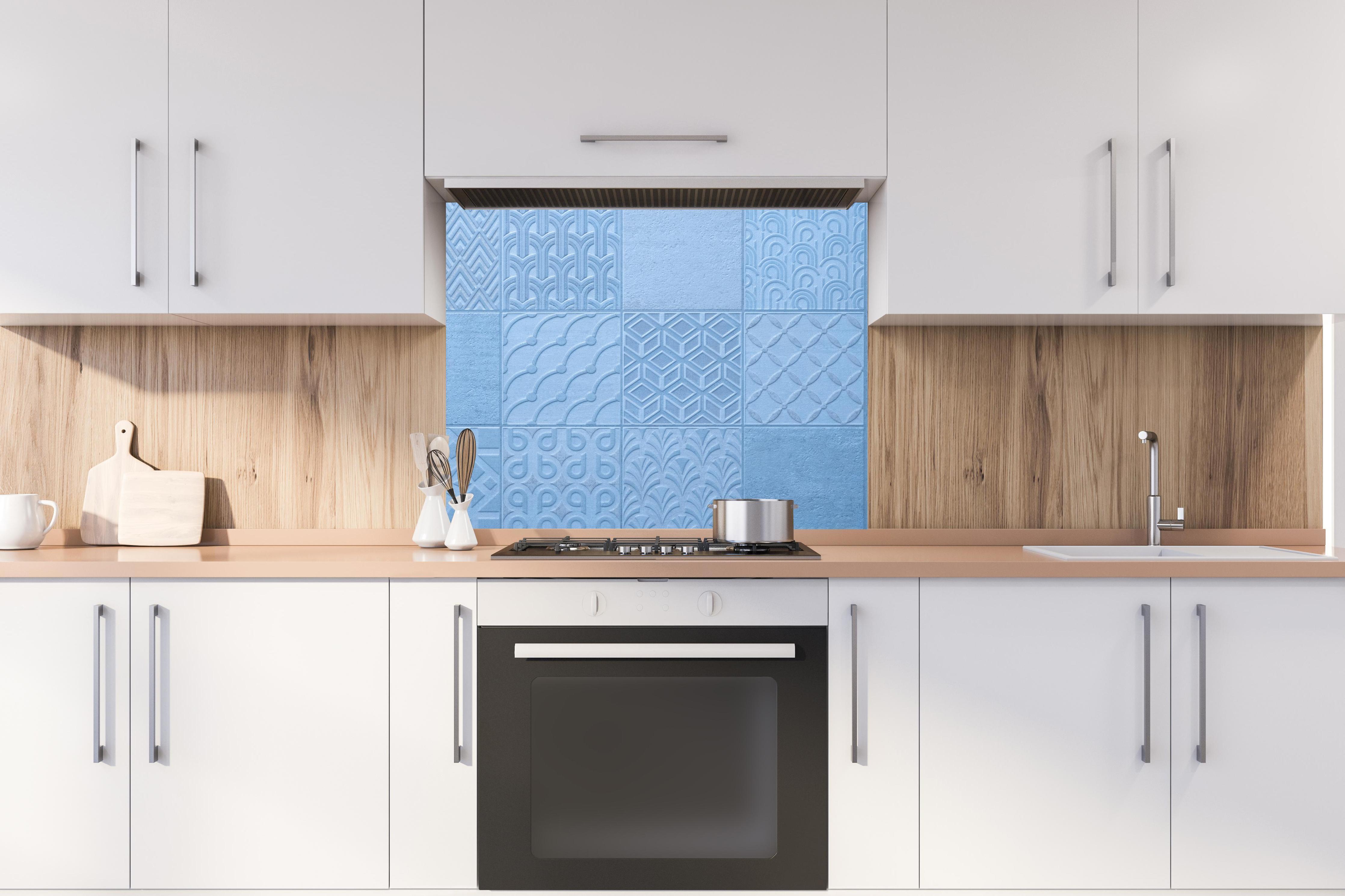Spritzschutz - Hellblaue Fliesenmuster hinter stilvollem Gasherd unter Dunstabzugshaube