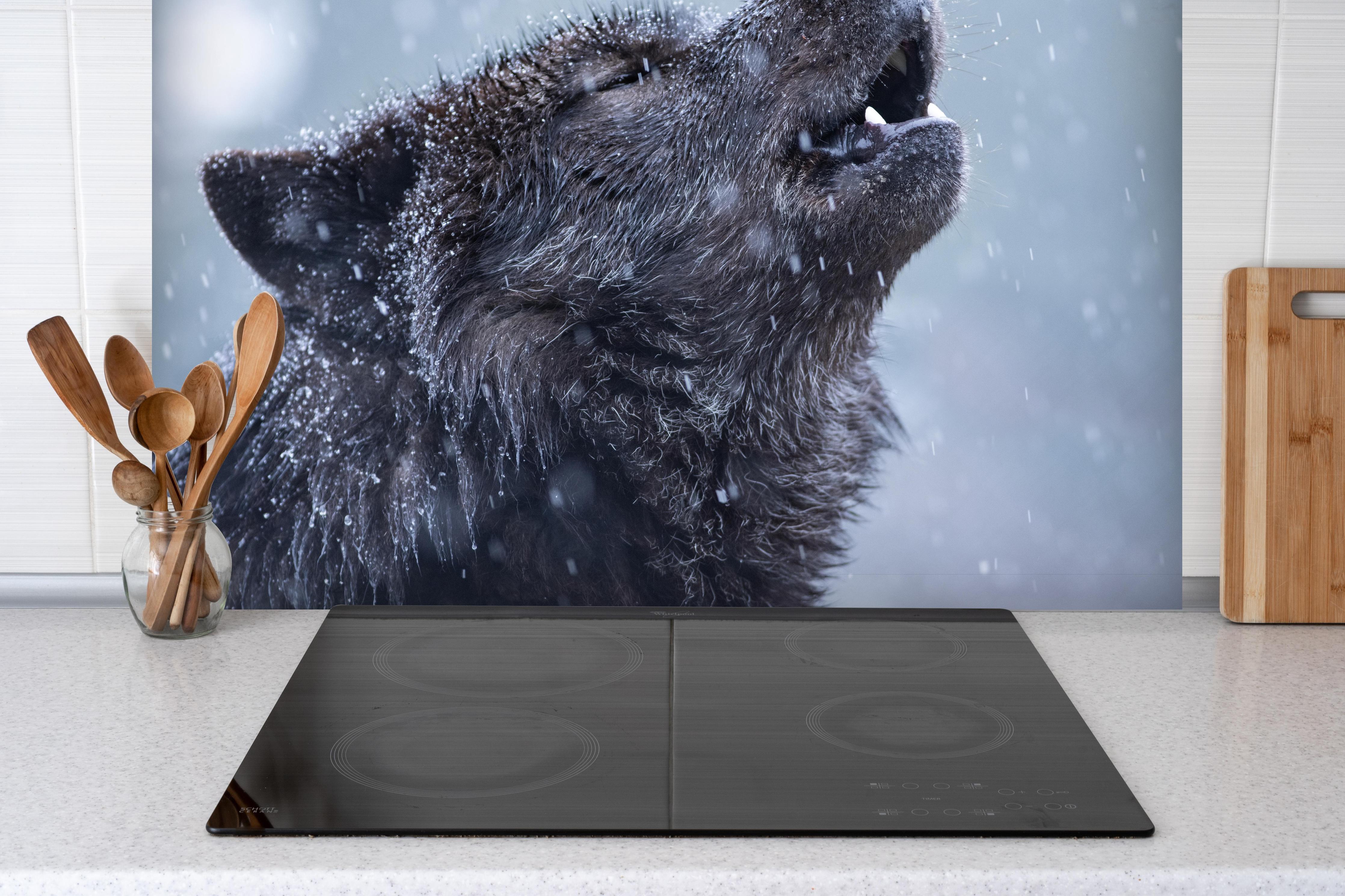 Spritzschutz - Heulender Wolf im Winter hinter einem Cerankochfeld zwischen Holz-Kochutensilien