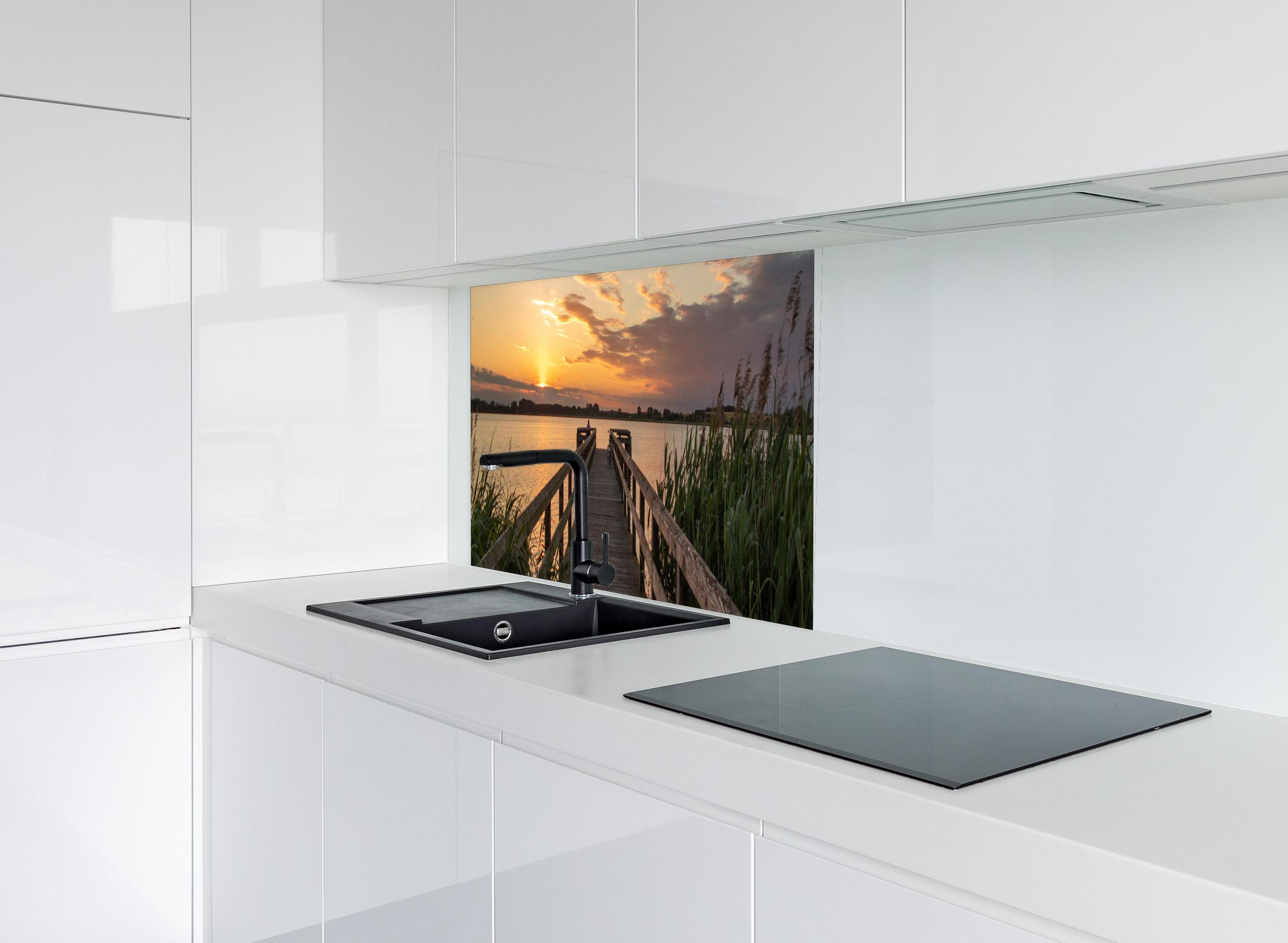 Spritzschutz - Holzsteg am Abend - Teterower See hinter modernem schwarz-matten Spülbecken in weißer Hochglanz-Küche