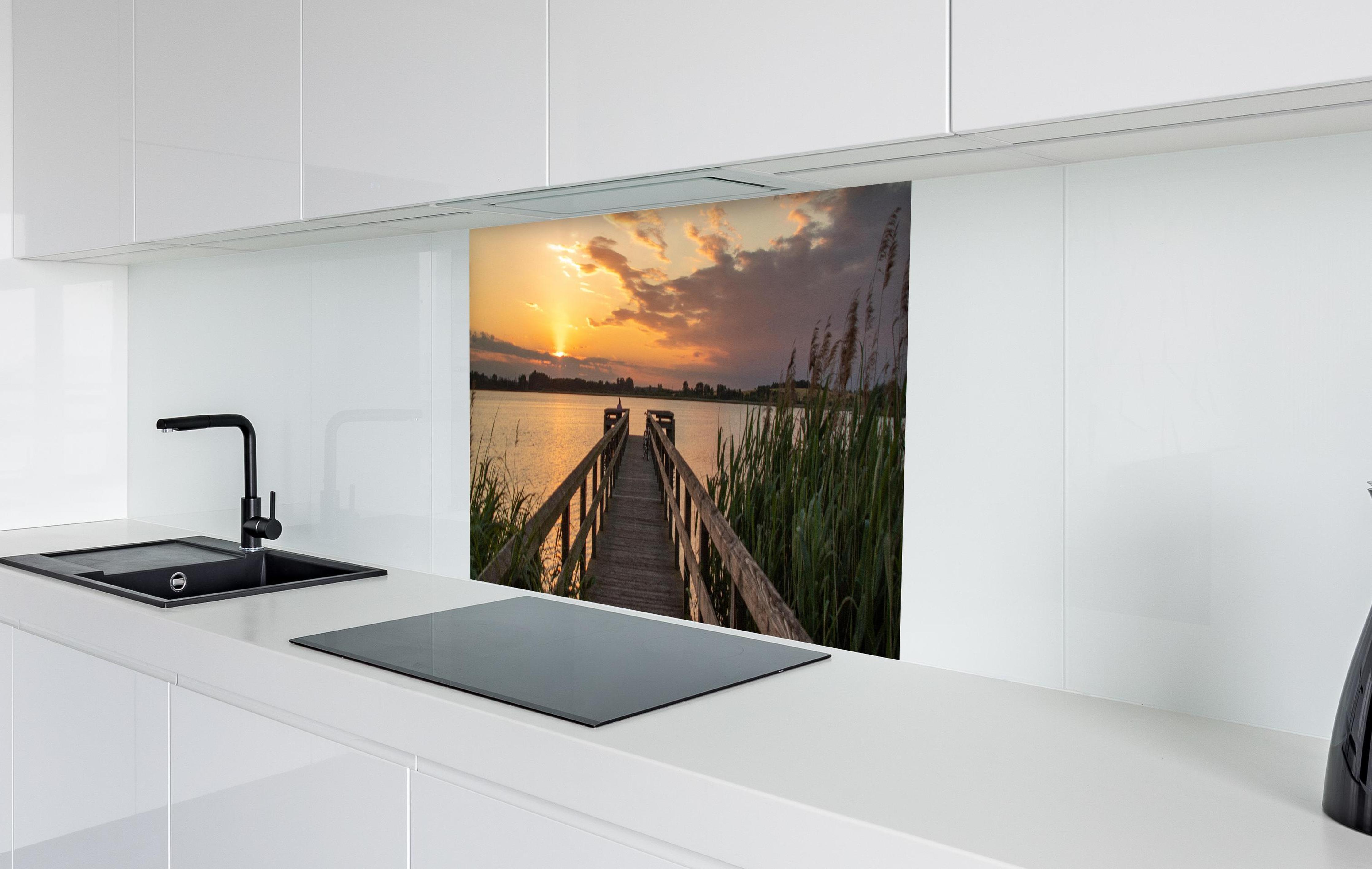Spritzschutz - Holzsteg am Abend - Teterower See in weißer Hochglanz-Küche hinter einem Cerankochfeld