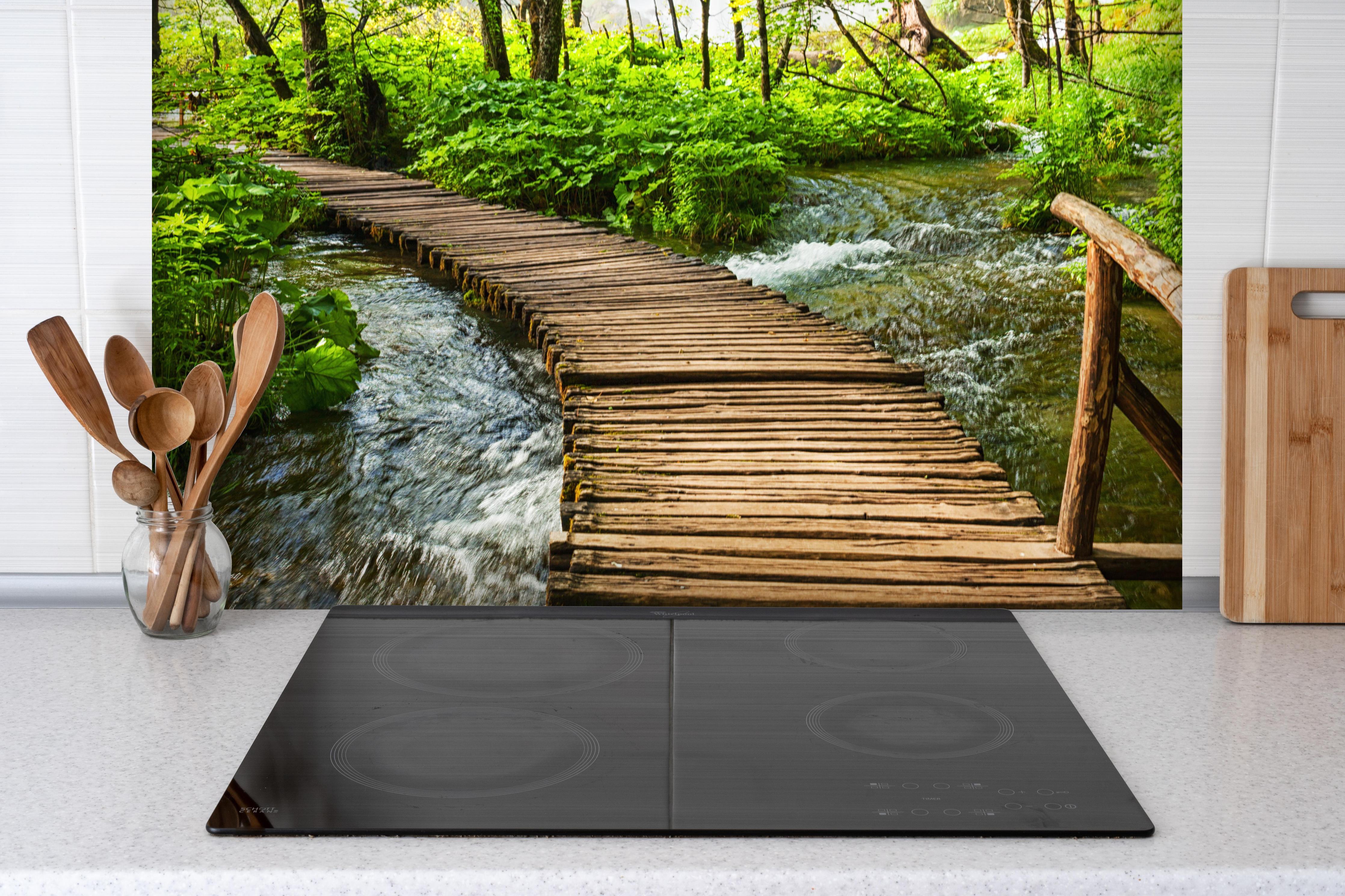 Spritzschutz - Idyllischer Dschungelpfad - Kroatien hinter einem Cerankochfeld zwischen Holz-Kochutensilien