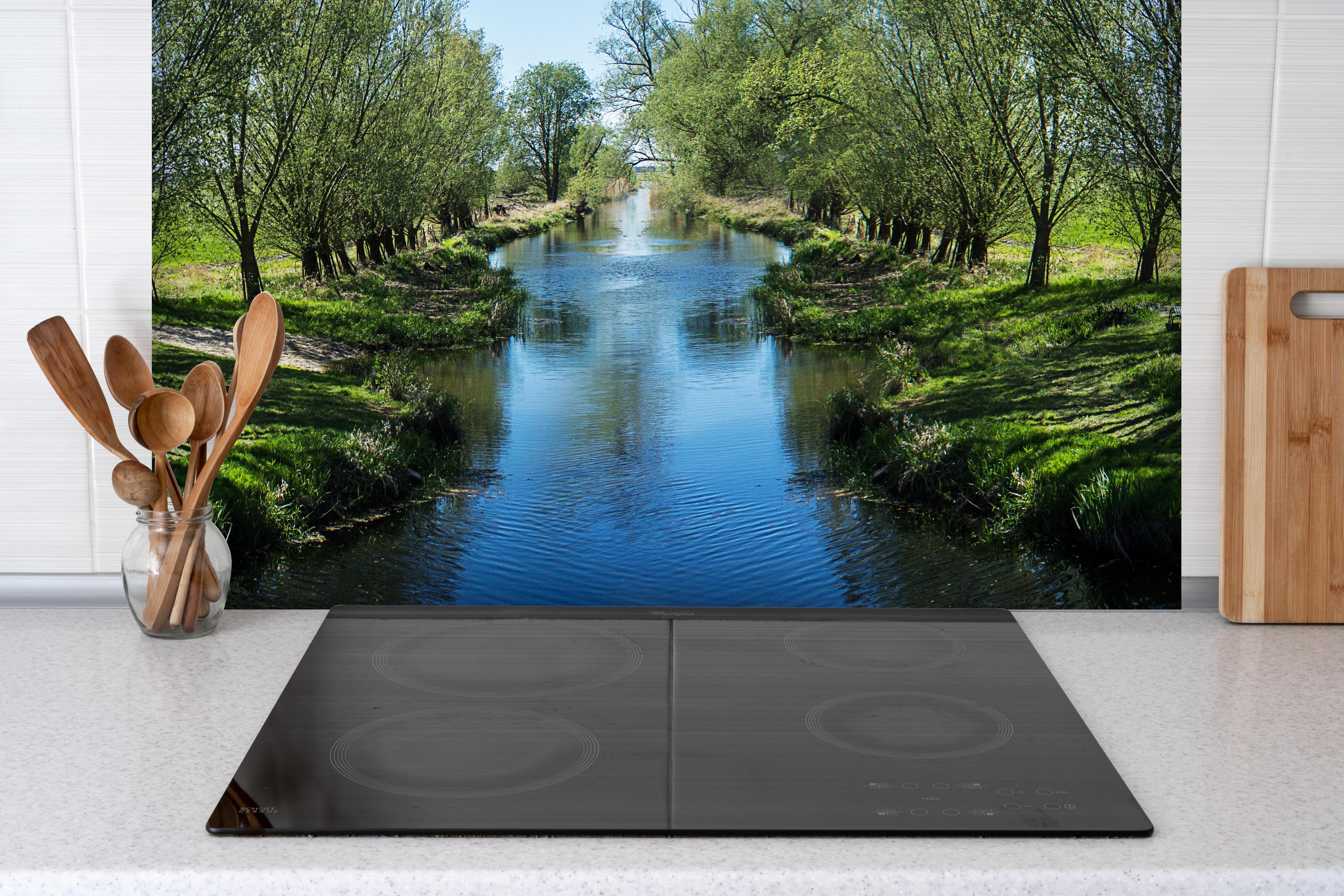 Spritzschutz - Idyllischer Fluss in Sachsen-Anhalt hinter einem Cerankochfeld zwischen Holz-Kochutensilien