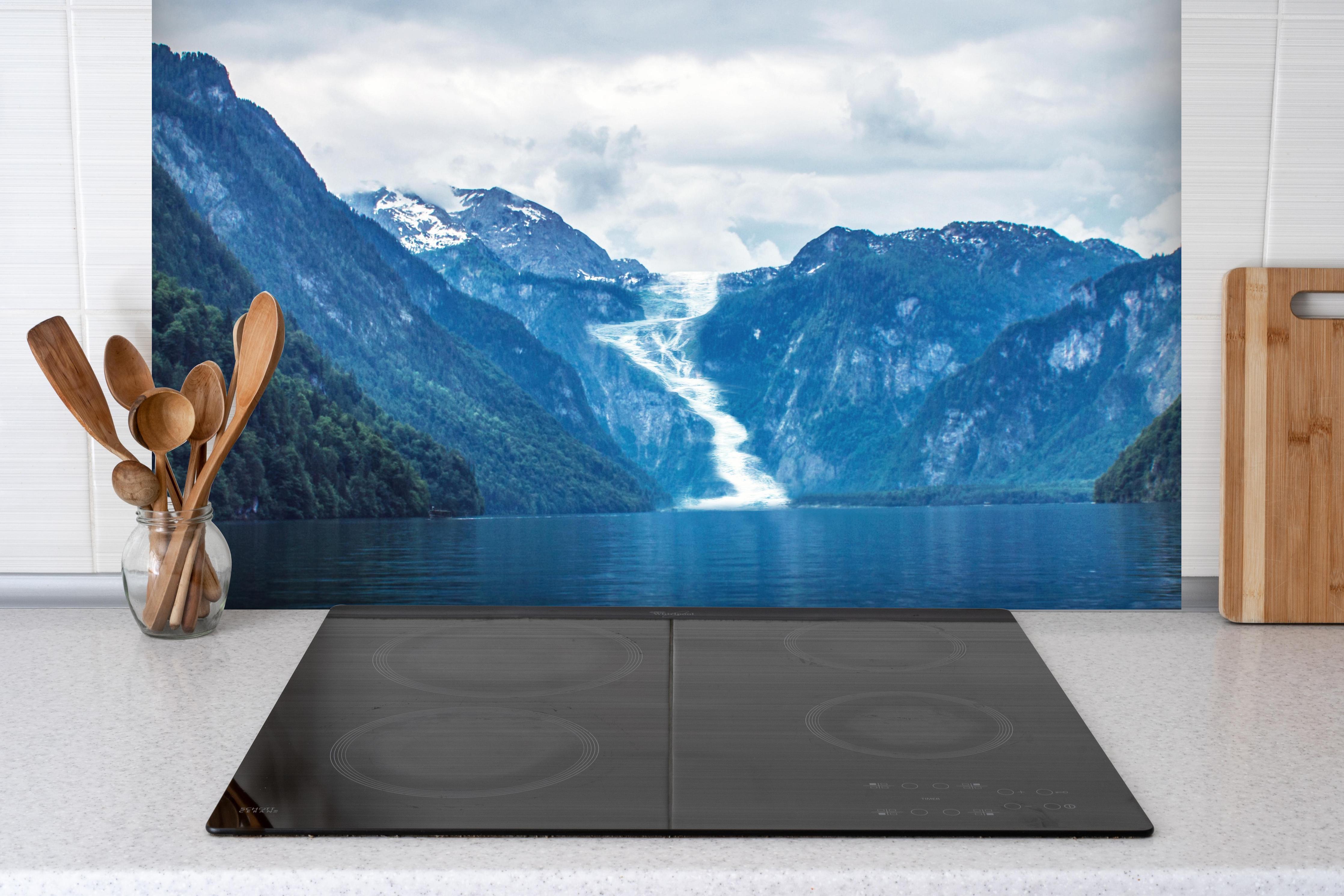 Spritzschutz - Idyllischer See in den Bergen hinter einem Cerankochfeld zwischen Holz-Kochutensilien