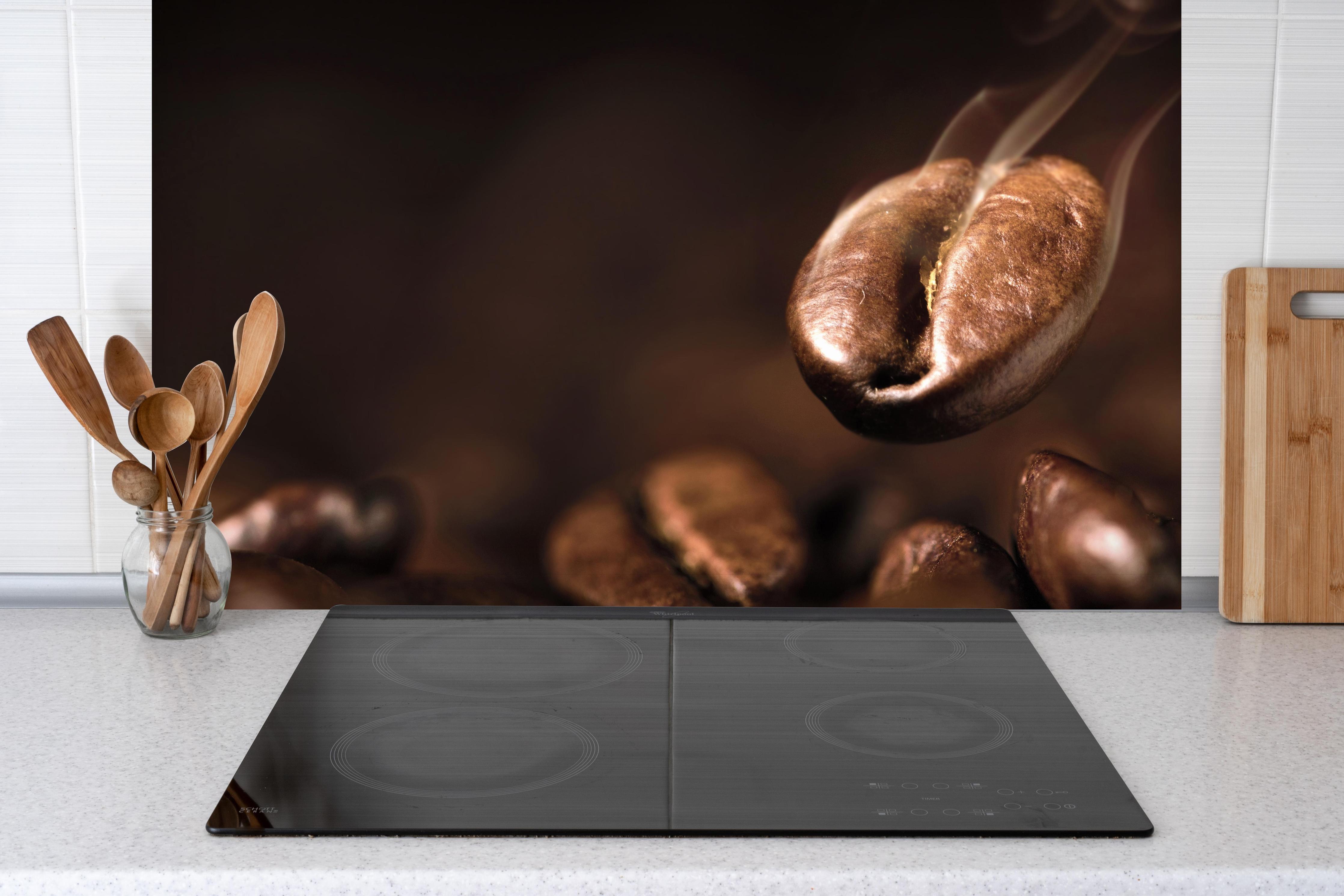 Spritzschutz - Kaffeebohnen Nahaufnahme hinter einem Cerankochfeld zwischen Holz-Kochutensilien