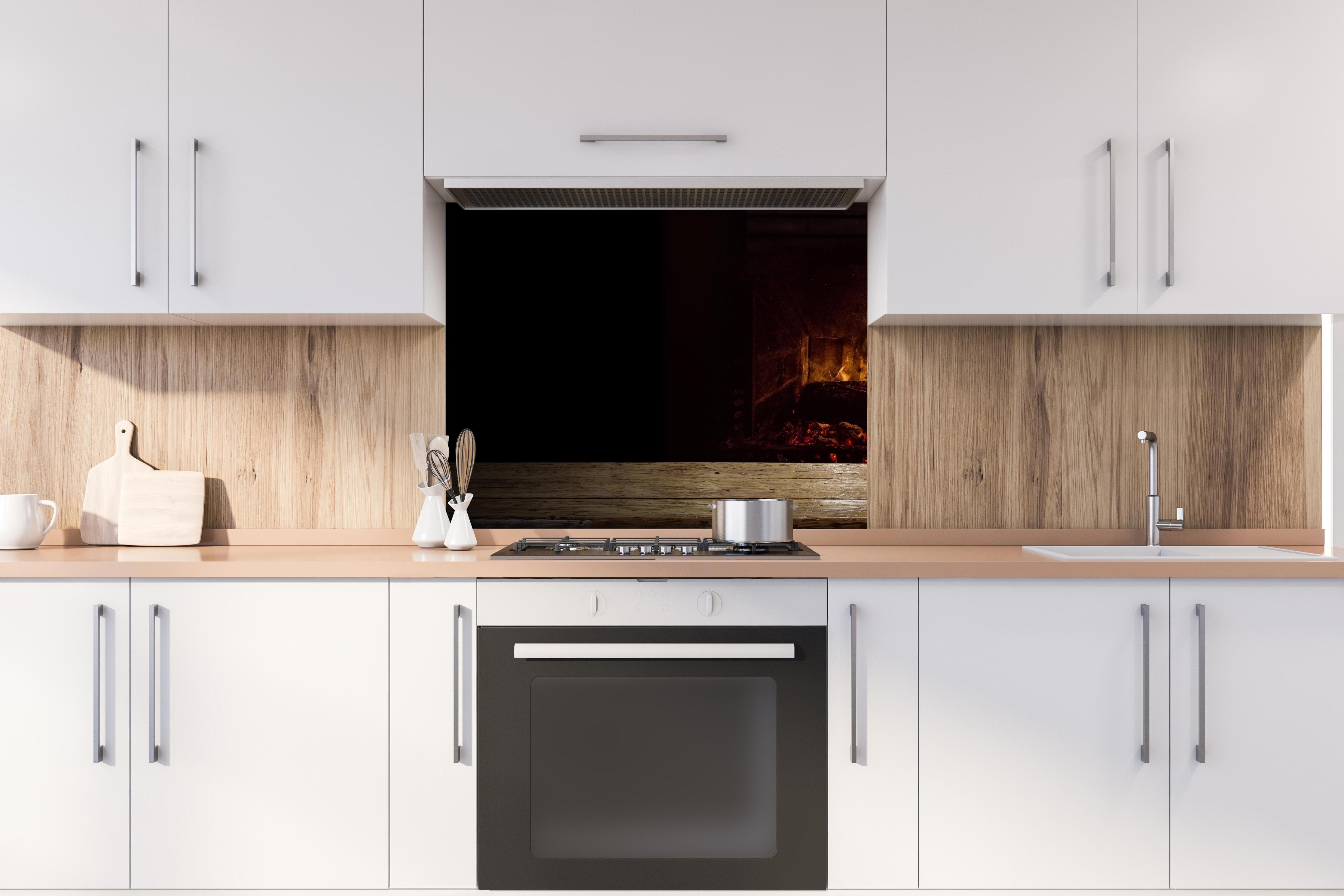 Spritzschutz - Kaminfeuer vor Holztisch hinter stilvollem Gasherd unter Dunstabzugshaube