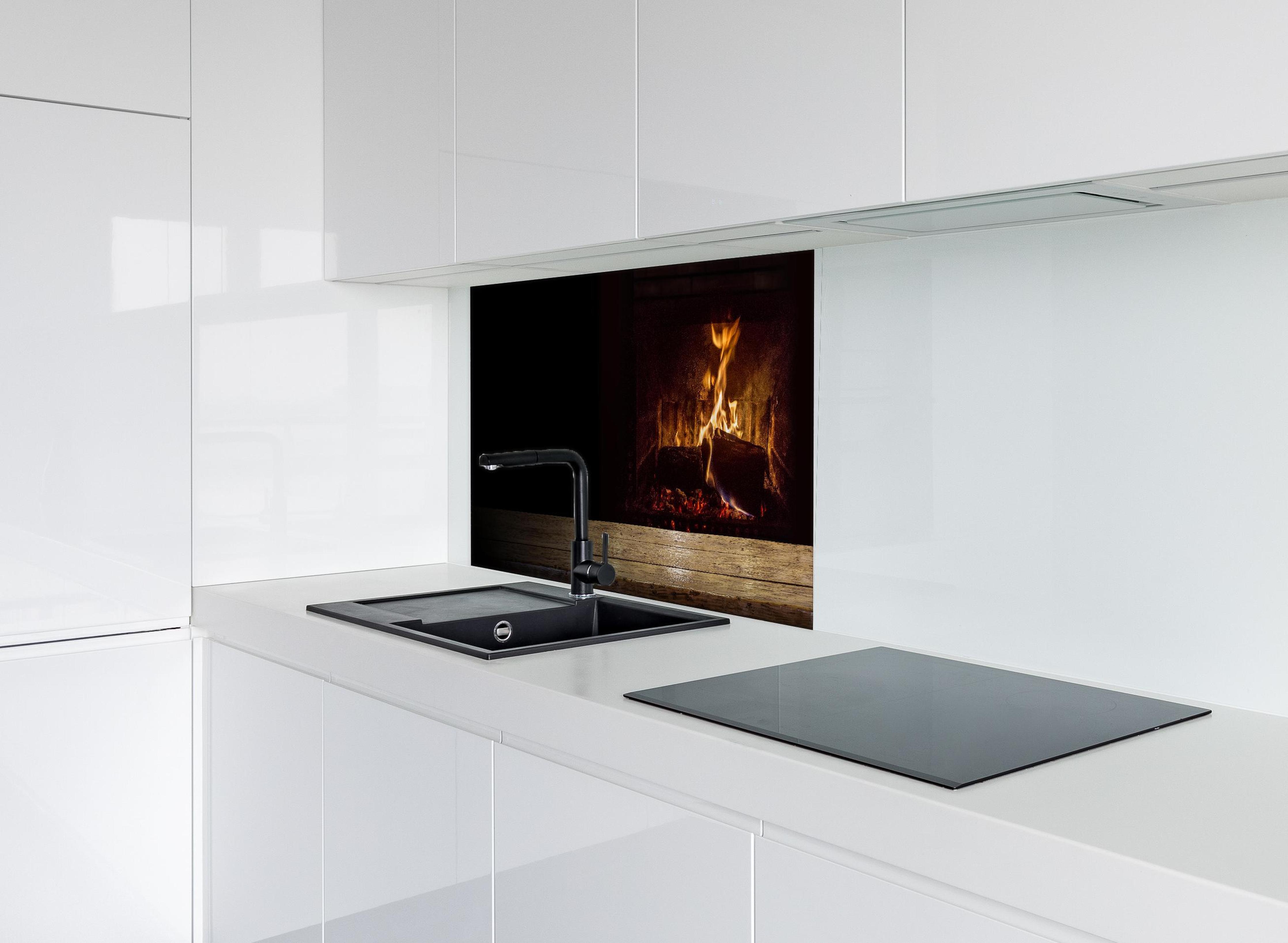 Spritzschutz - Kaminfeuer vor Holztisch hinter modernem schwarz-matten Spülbecken in weißer Hochglanz-Küche