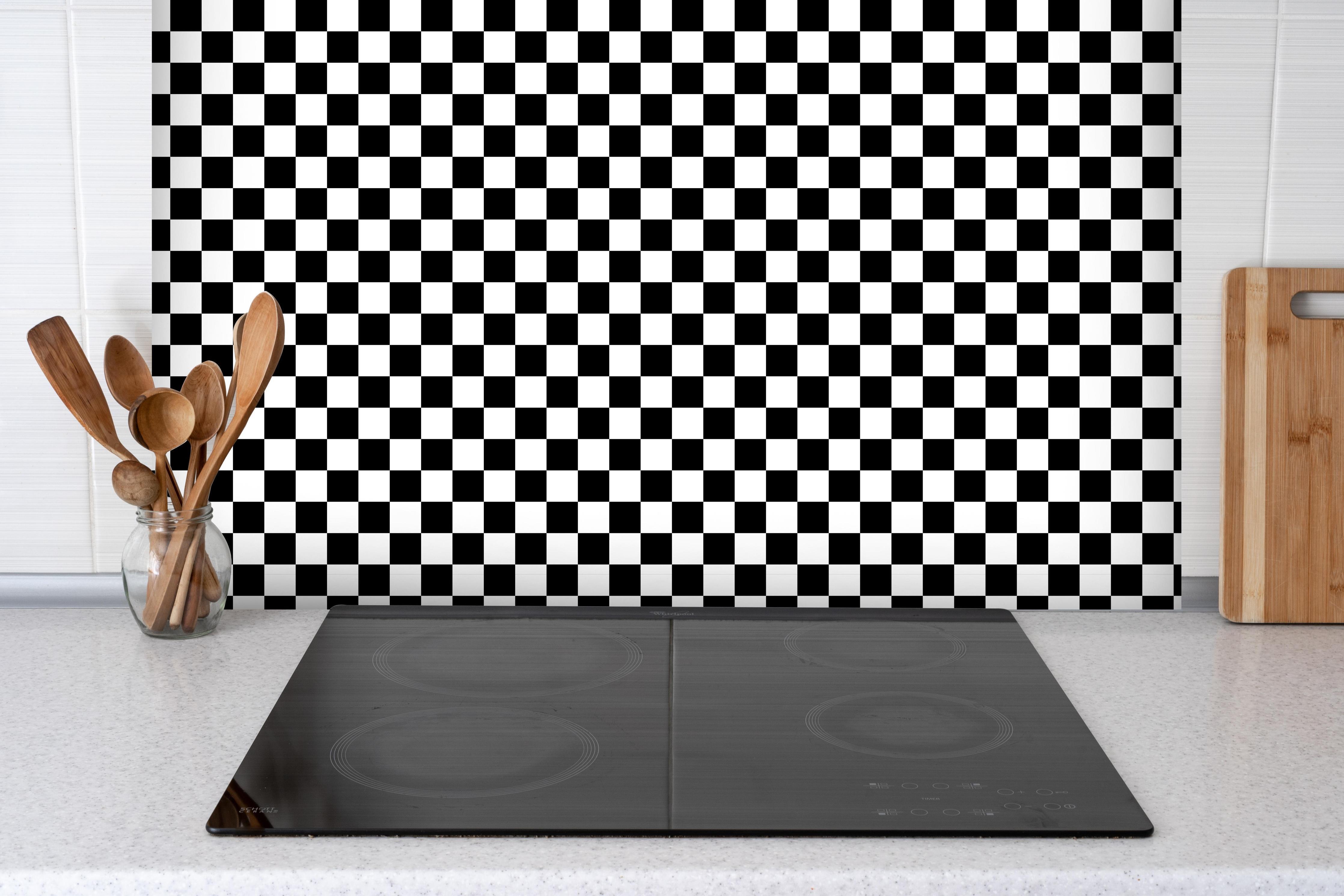 Spritzschutz - Kariertes Schach-Muster hinter einem Cerankochfeld zwischen Holz-Kochutensilien