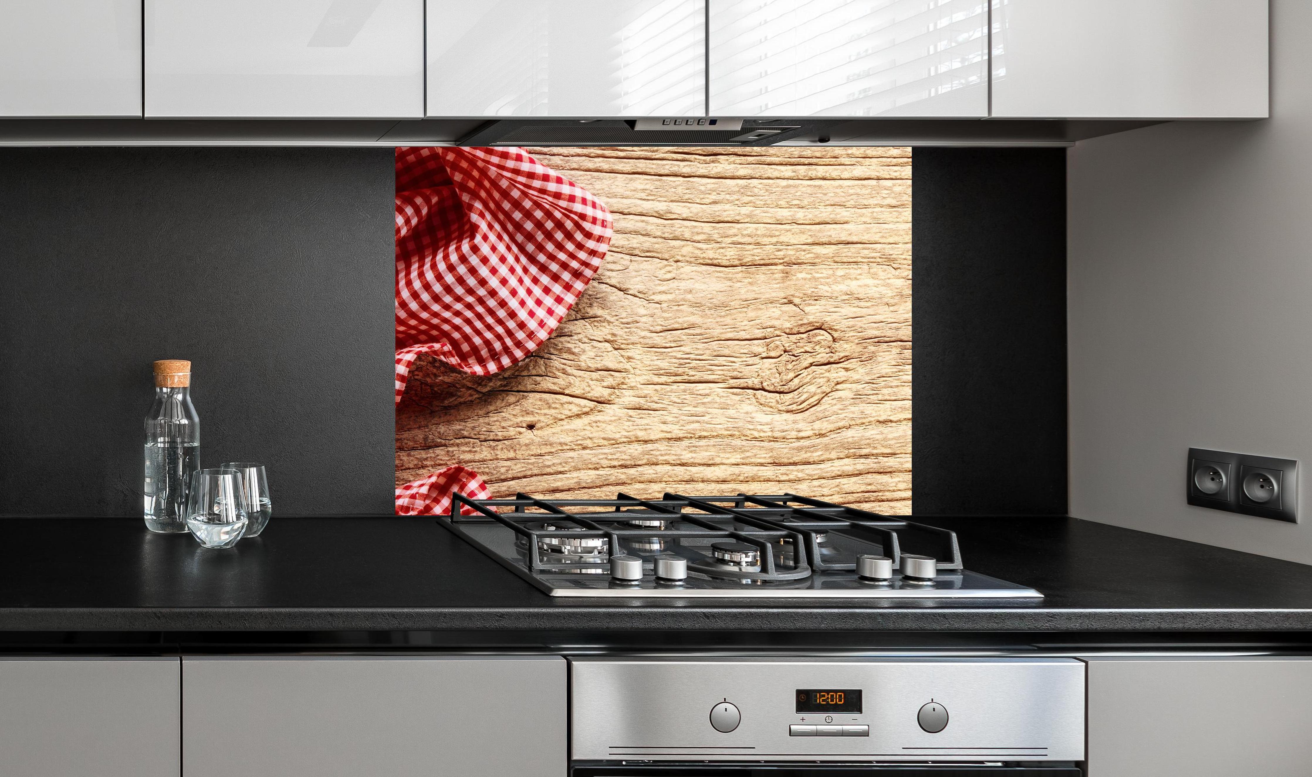 Spritzschutz - Kariertes Tischtuch auf Holztisch an edler Anthrazit-Wand hinter silbernem Gasherd