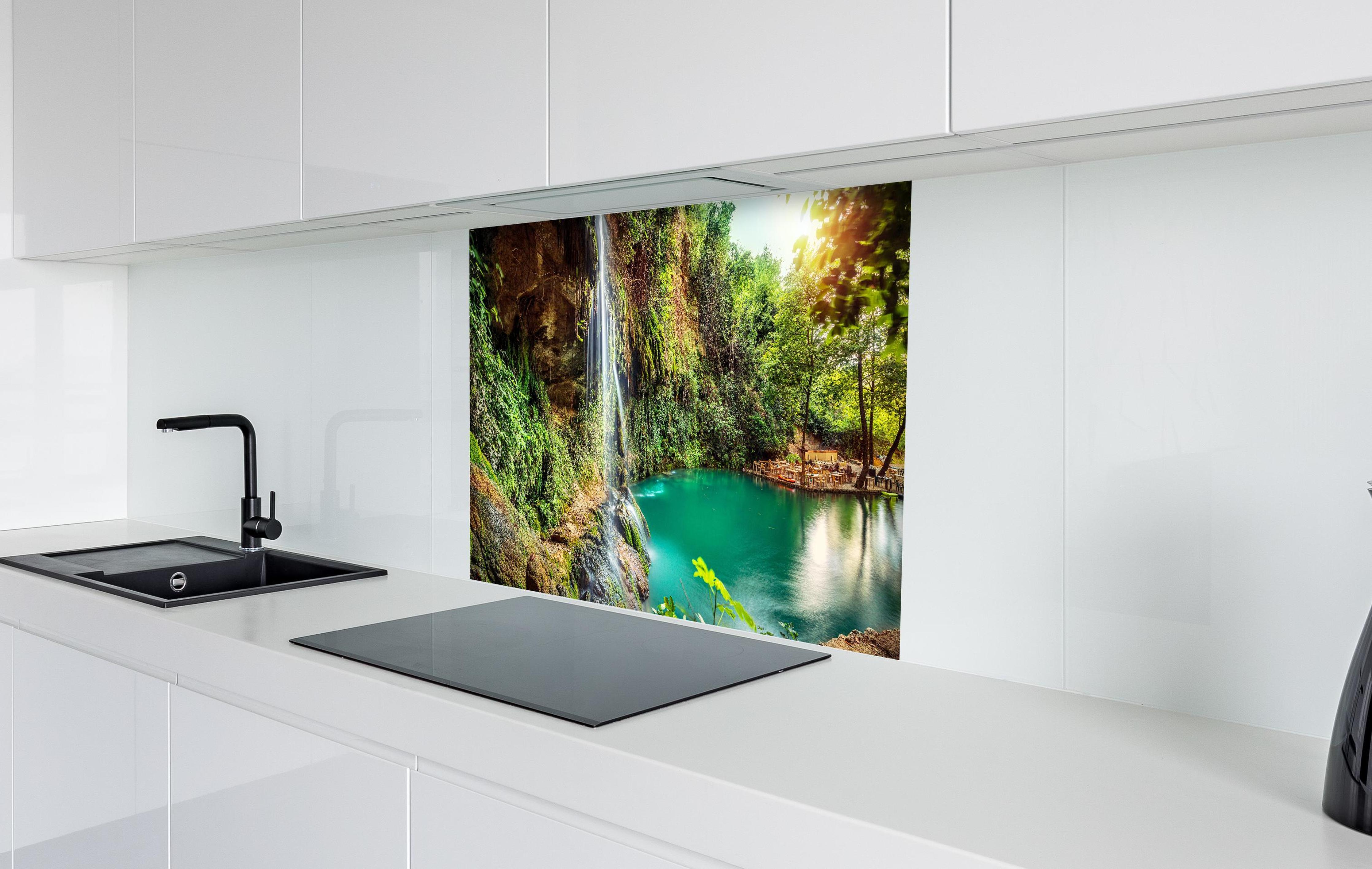 Spritzschutz - Kaskade mit klarem Bach im Libanon in weißer Hochglanz-Küche hinter einem Cerankochfeld